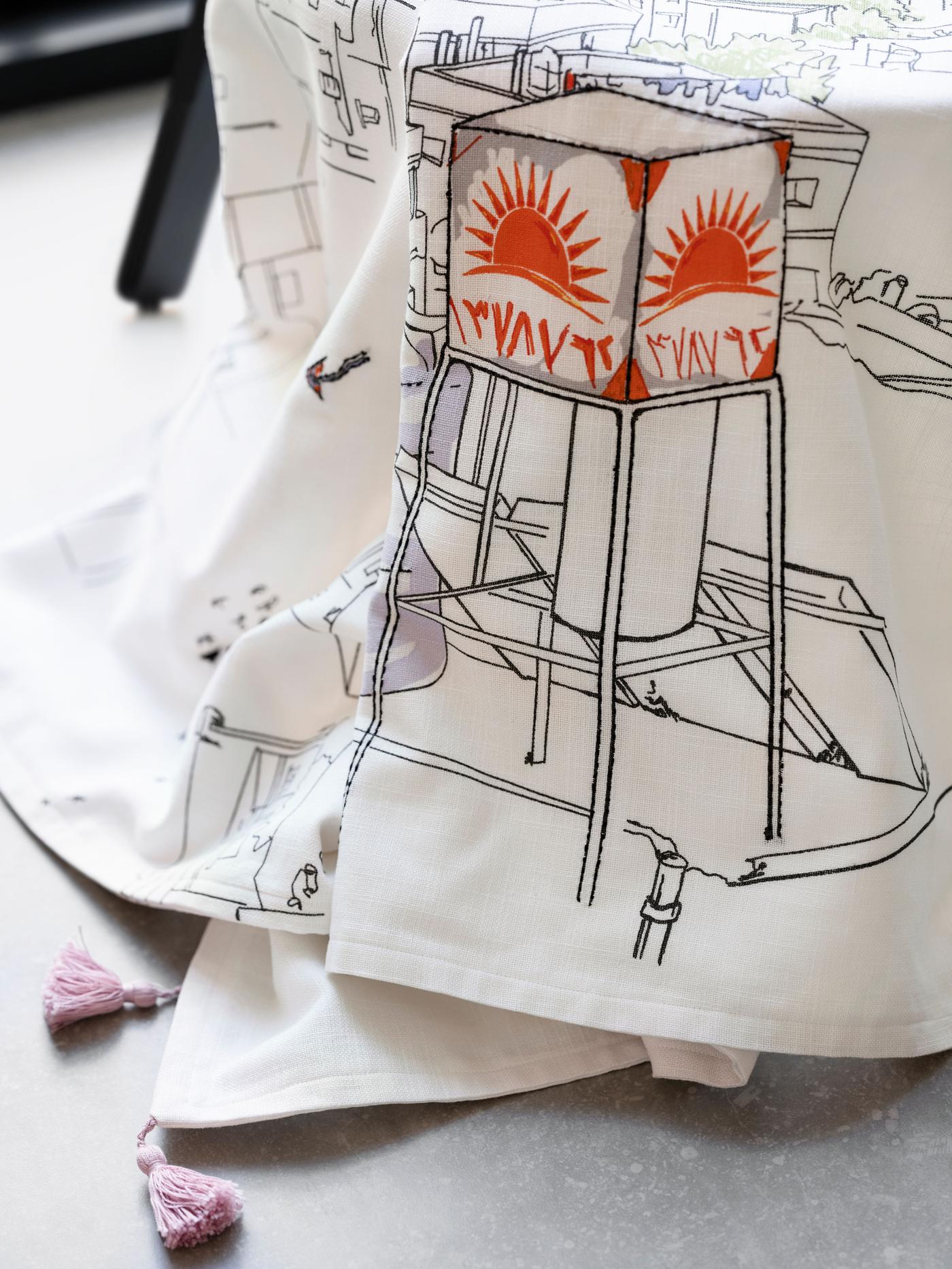 A piece of fabric is draped. On the fabric is a drawing of a water tower.