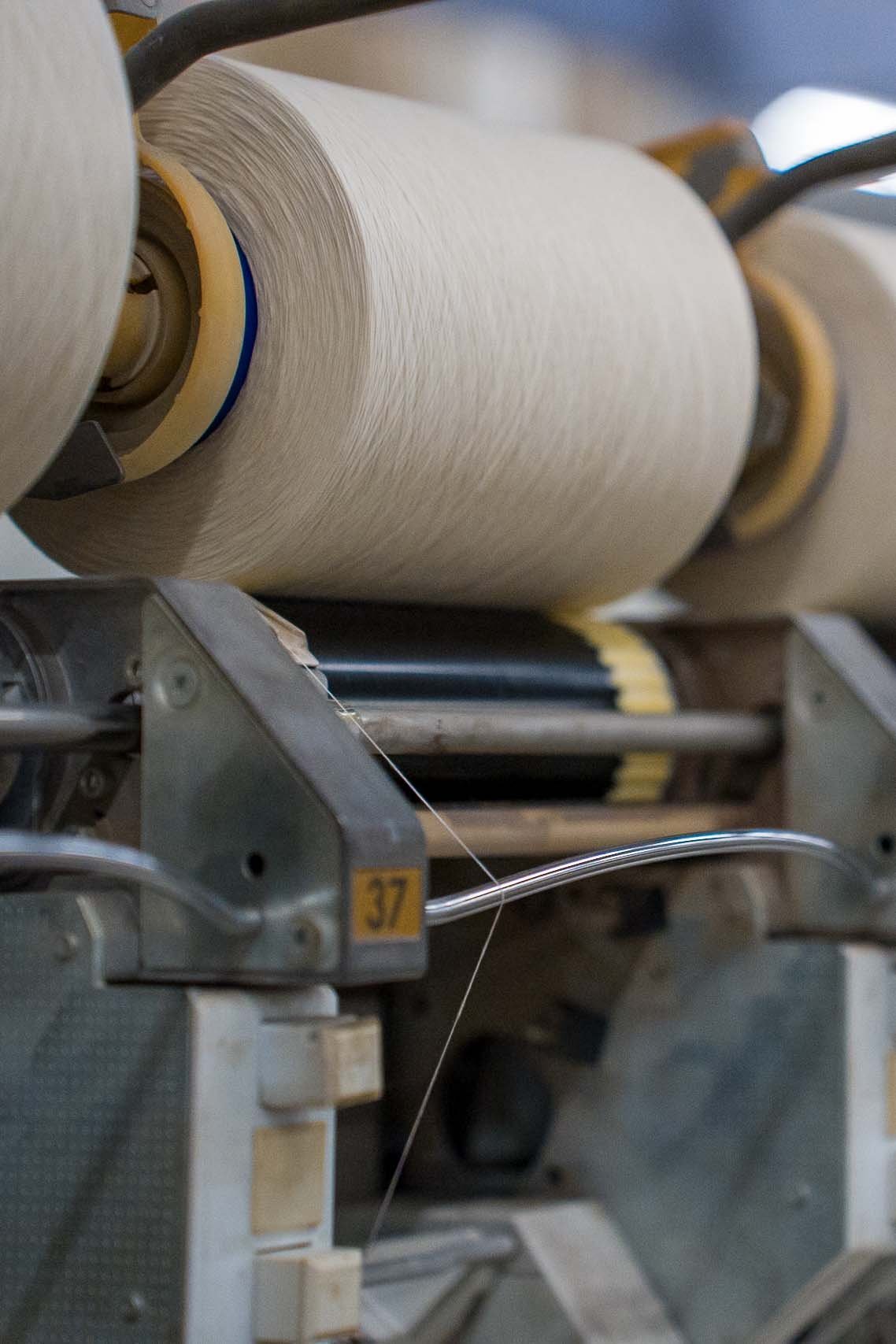 Cotton thread is wound onto a bobbin.