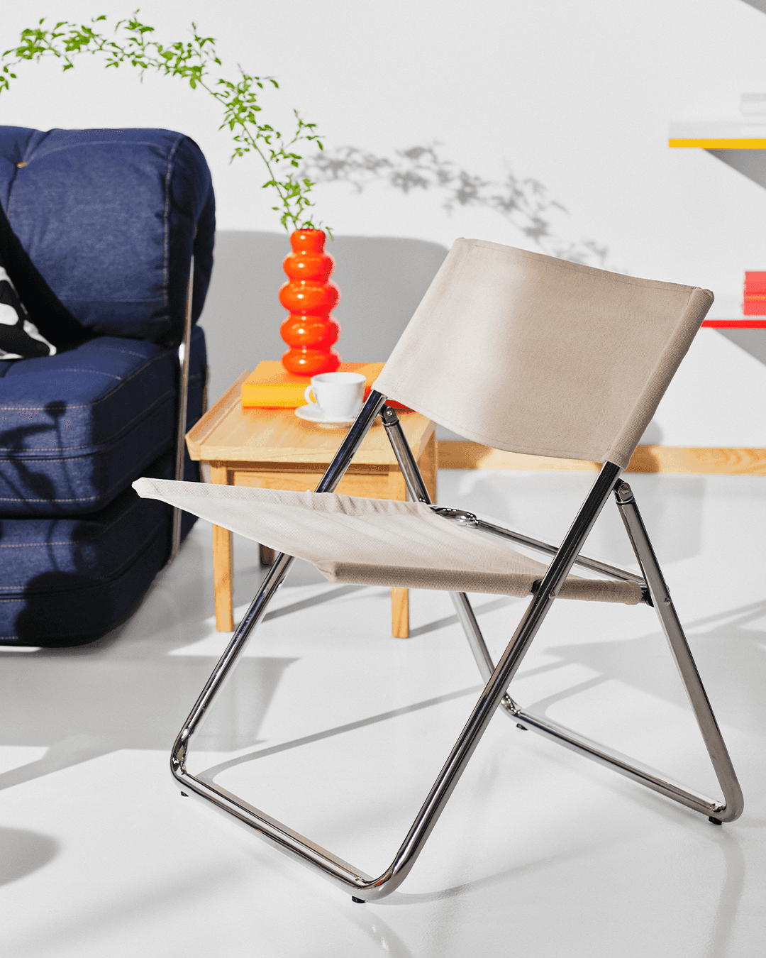 The colour cutout of the MOFALLA foldable chair transforms into a white roomset.