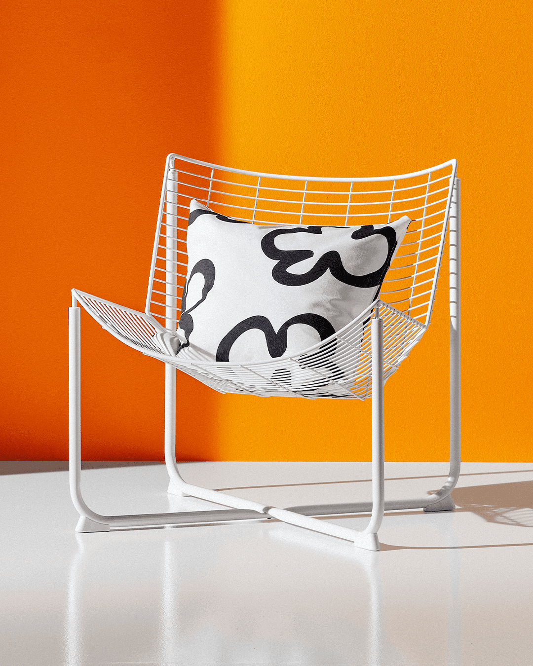 An orange and white backdrop appears behind the cutout of a SKÅLBODA armchair.