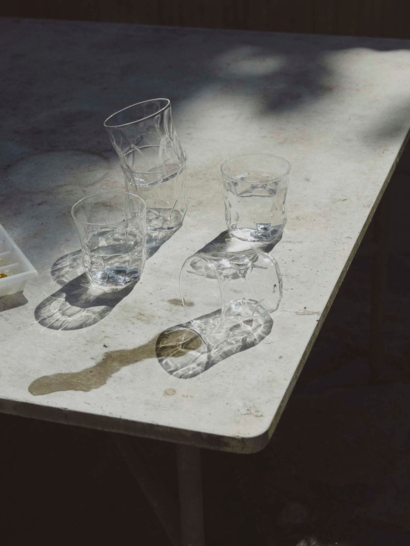 Glasses from the BASTUA collection on a grey table.