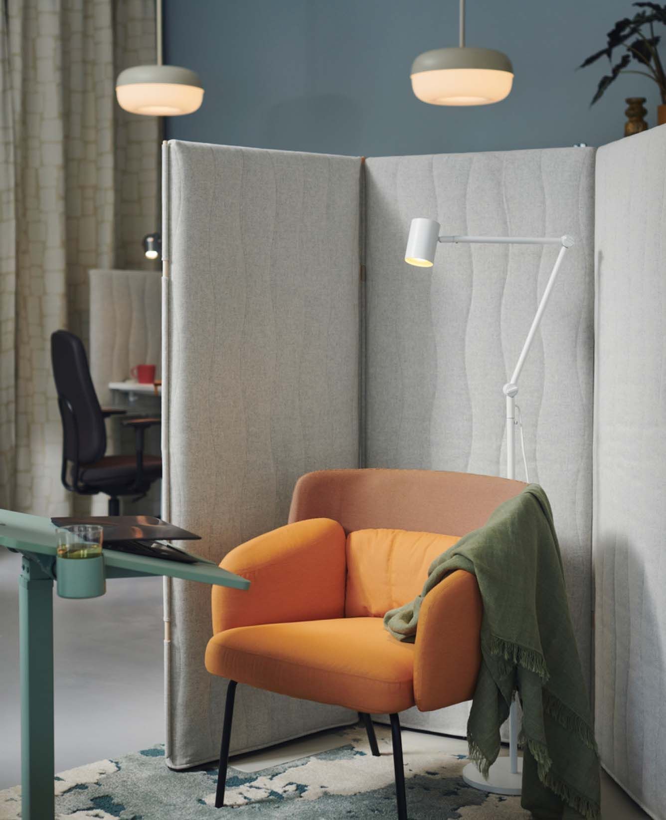 A MITTZON laptop table with castors in front of a BINGSTA armchair surrounded by a MITTZON acoustic screen, floor standing.