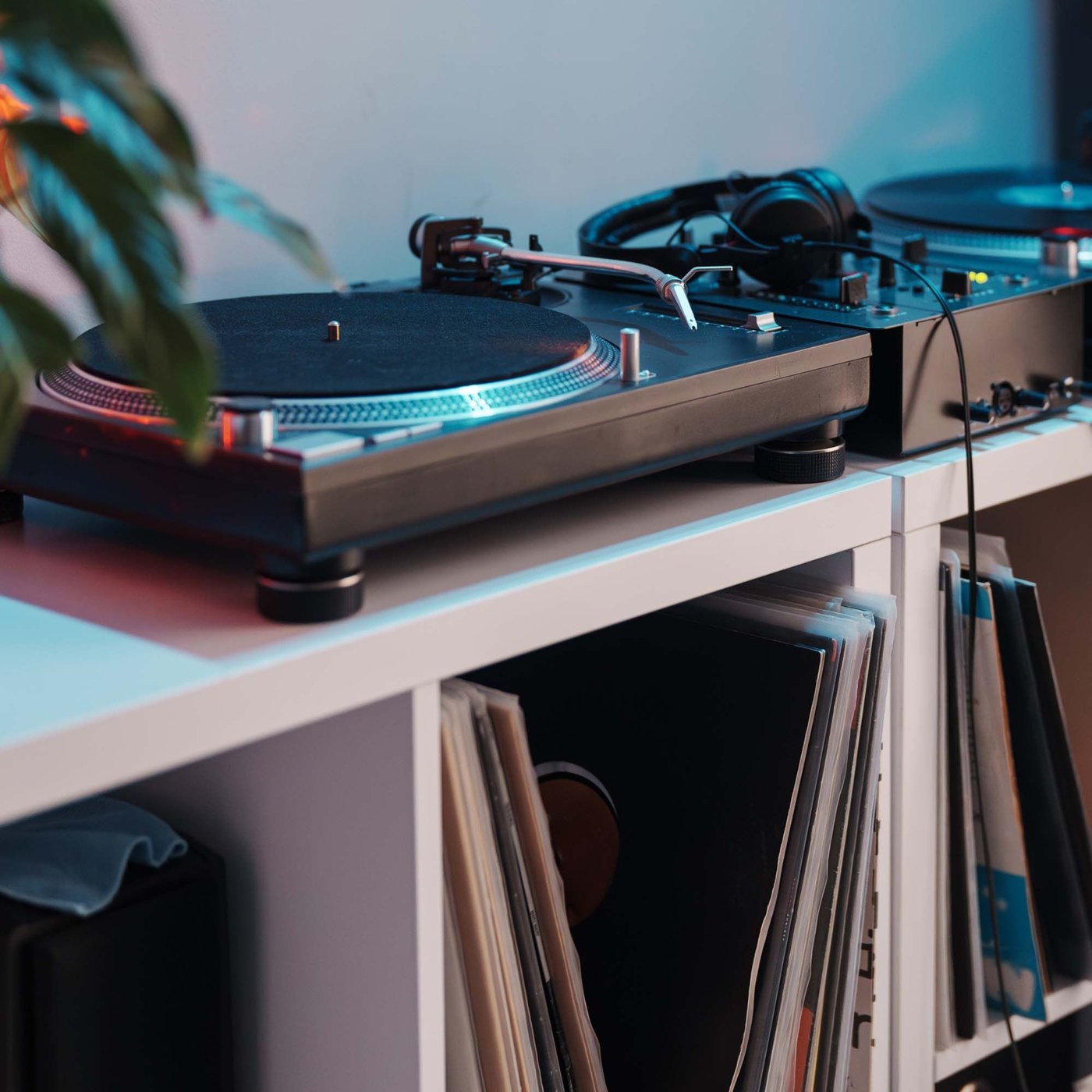 A vinyl player on a white shelf with vinyl records.