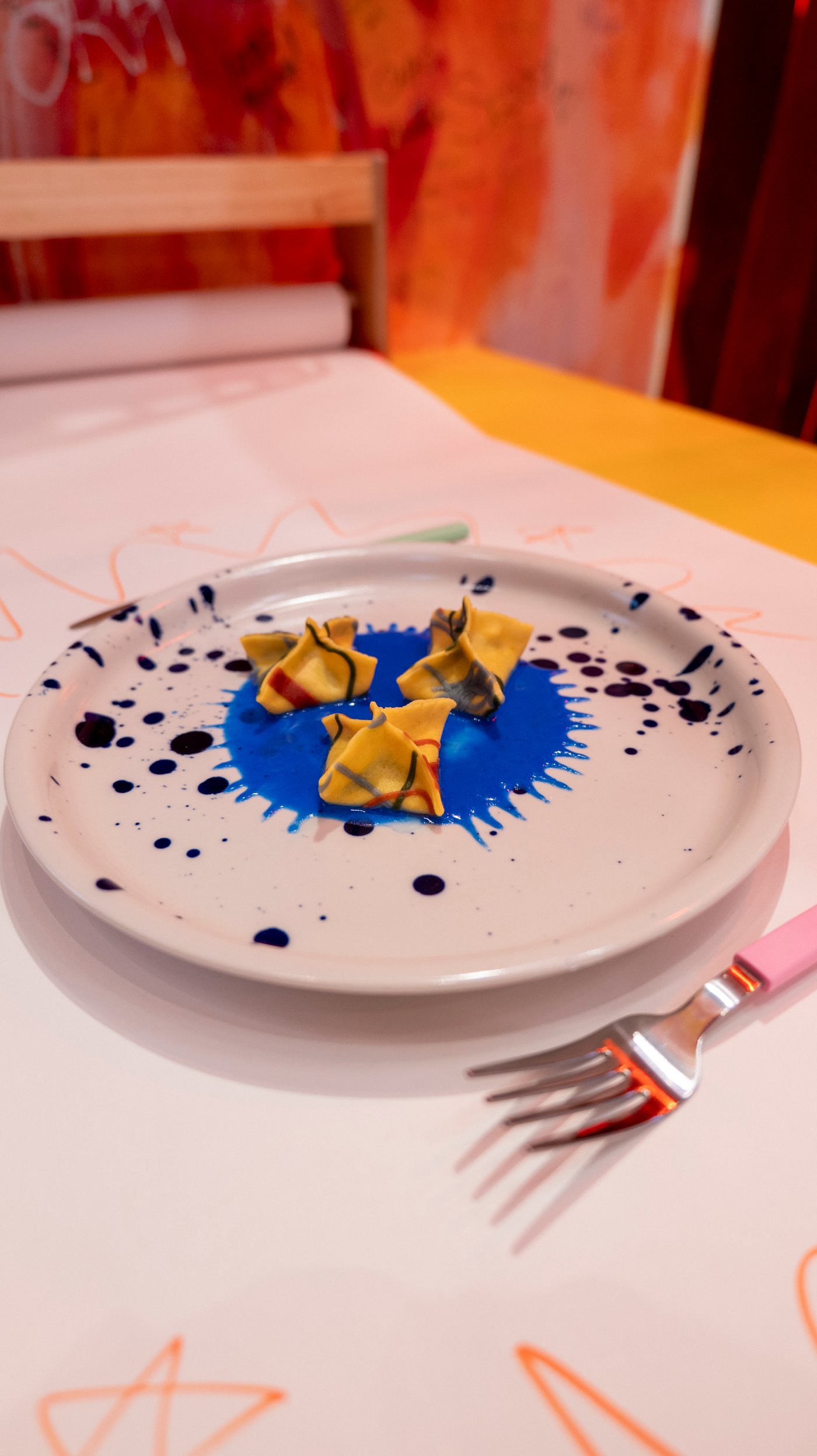 Three colourful ravioli on a patterned/blue SILVERSIDA plate.