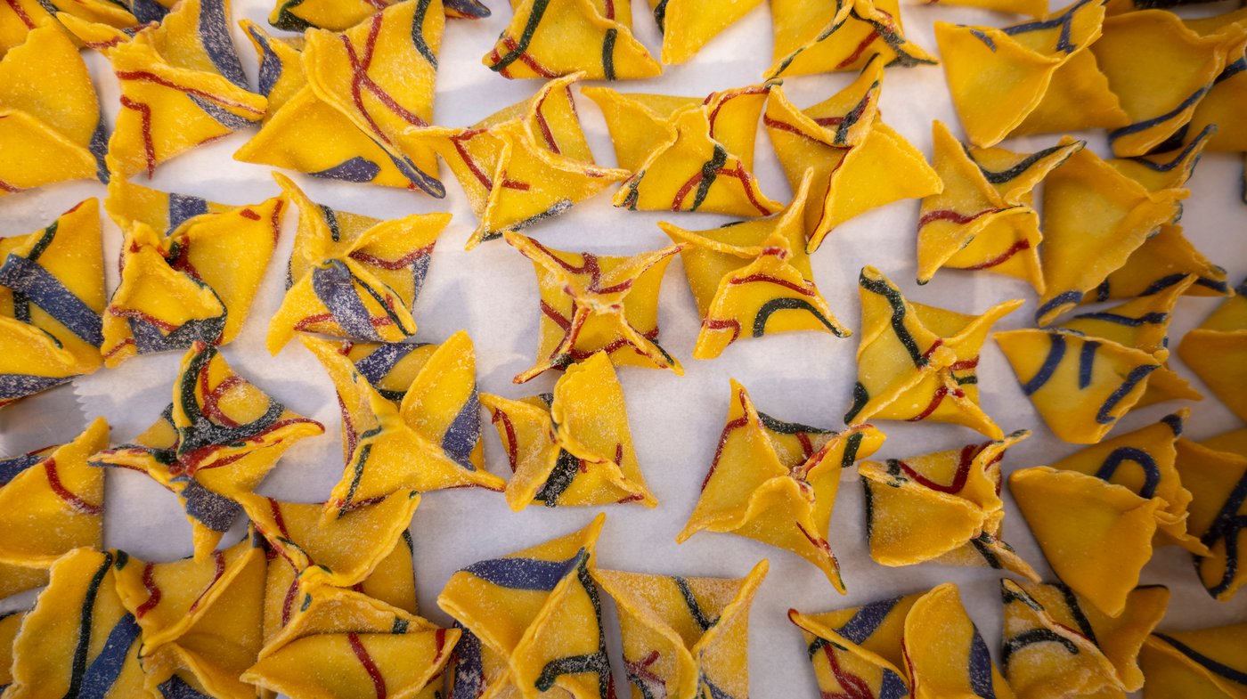 A tray of uncooked, colourful ravioli.