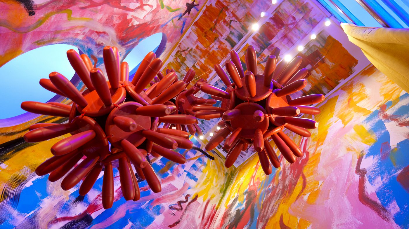 Two decorative features made up of a collection of red MAMMUT children's stools connected together by their seats.