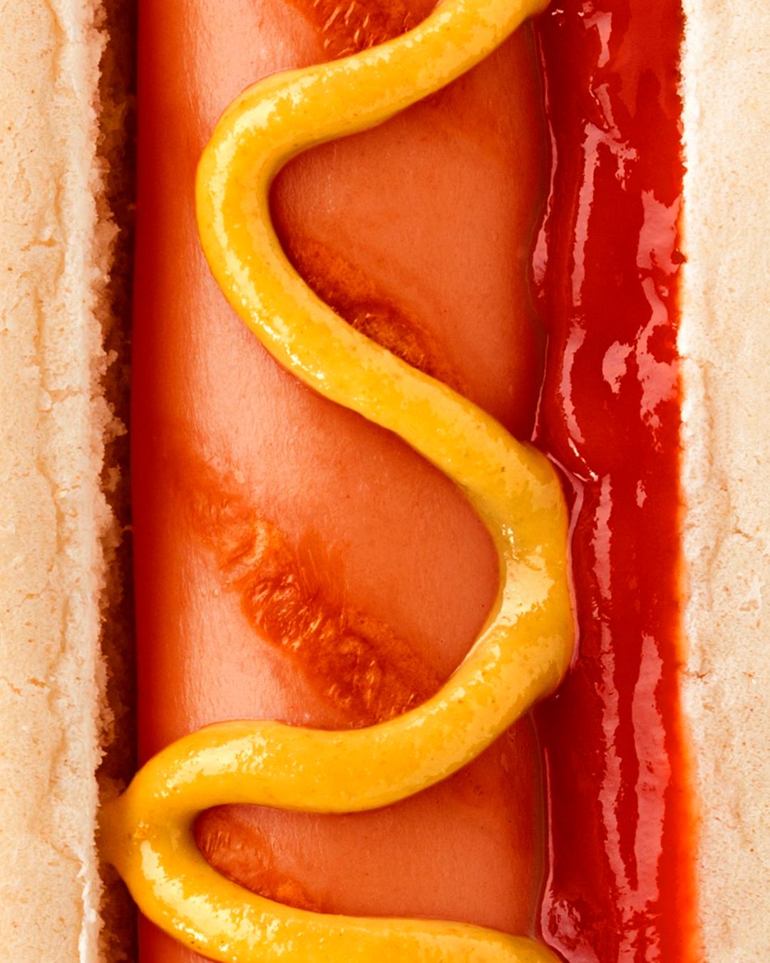 A close-up of a hotdog with ketchup and mustard.