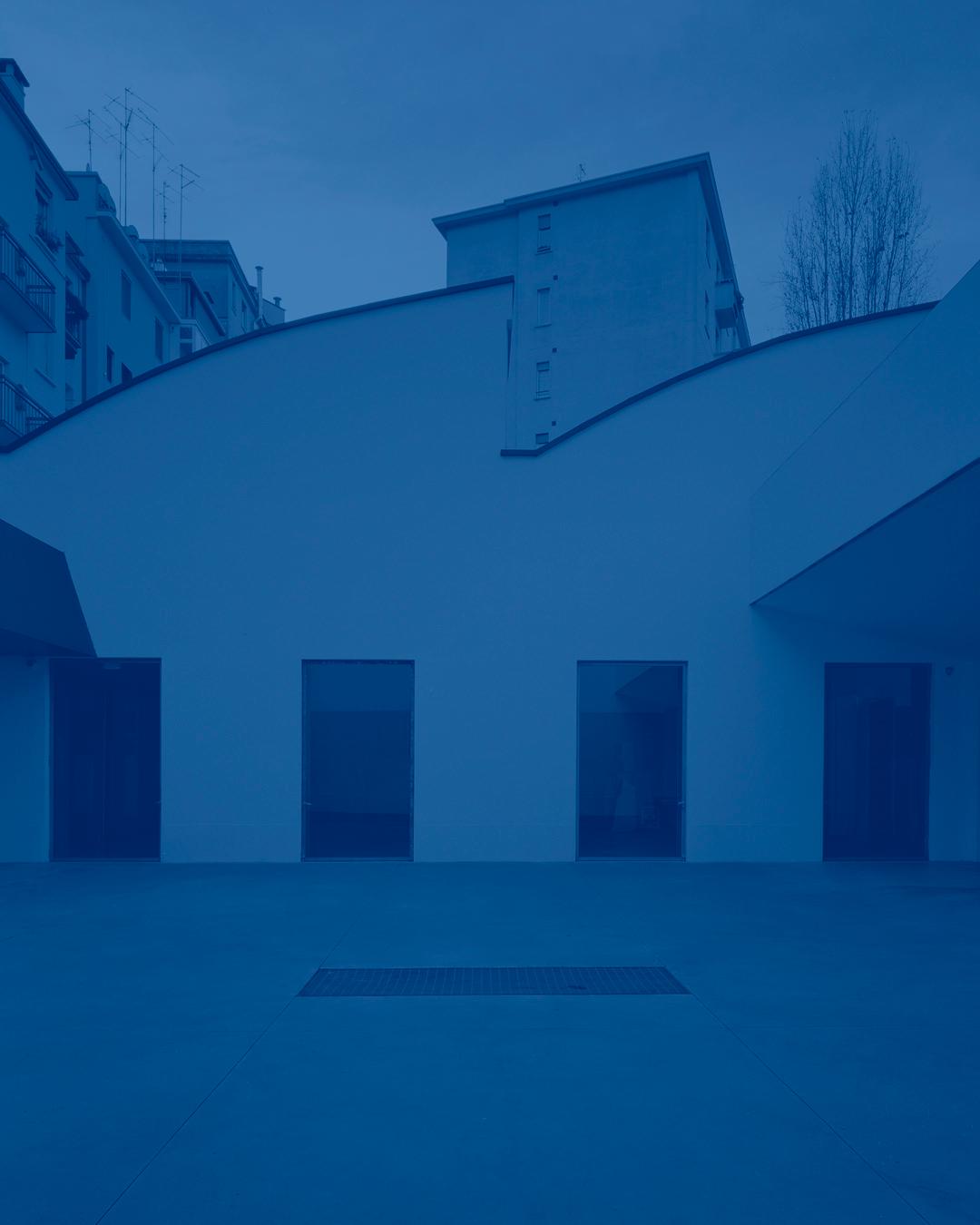 The facade of a white building, with a blue colour overlay.