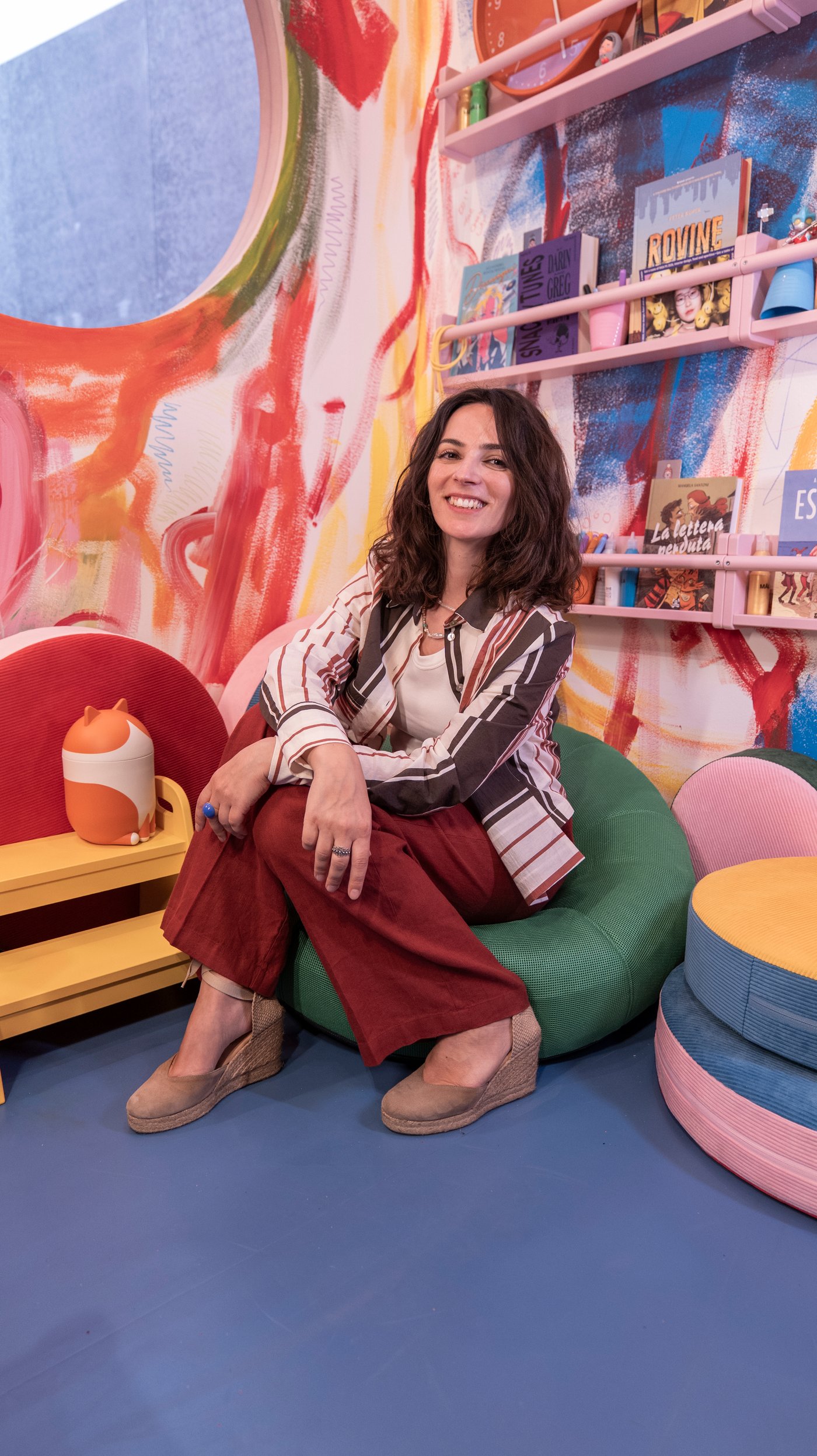 A portrait of Alessandra Lauria sitting in a green chair.