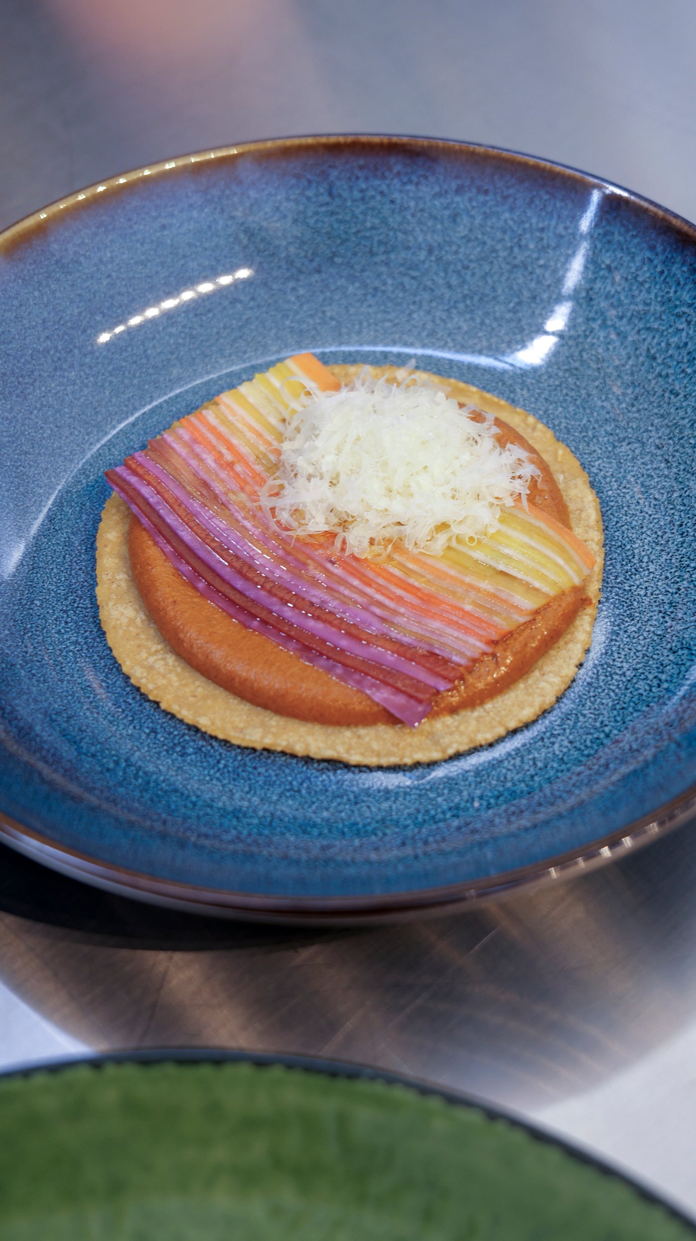 A blue plate with colourful food on an open taco.