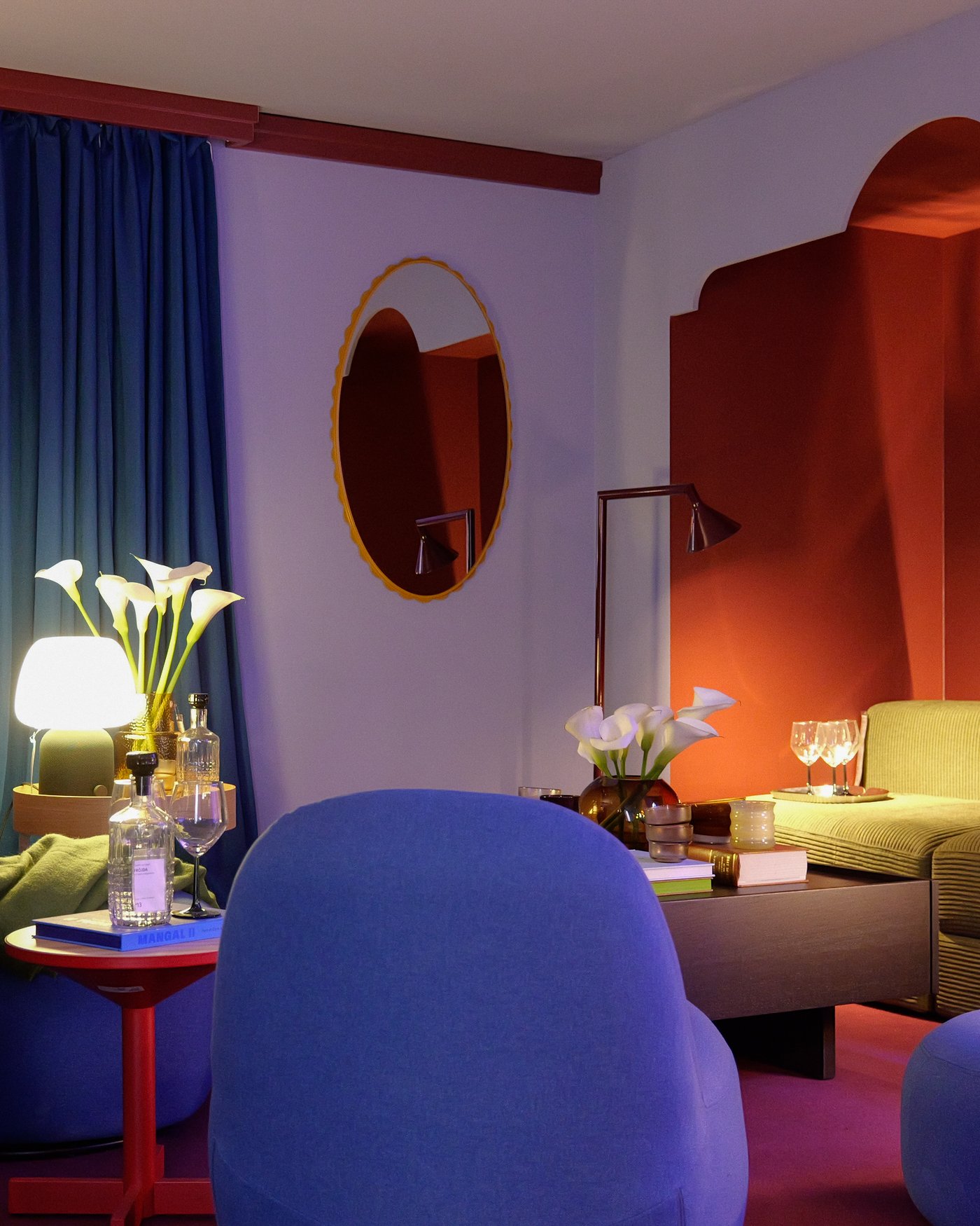 A colourful lilac living room with blue curtains and a blue chair, with mood lighting.