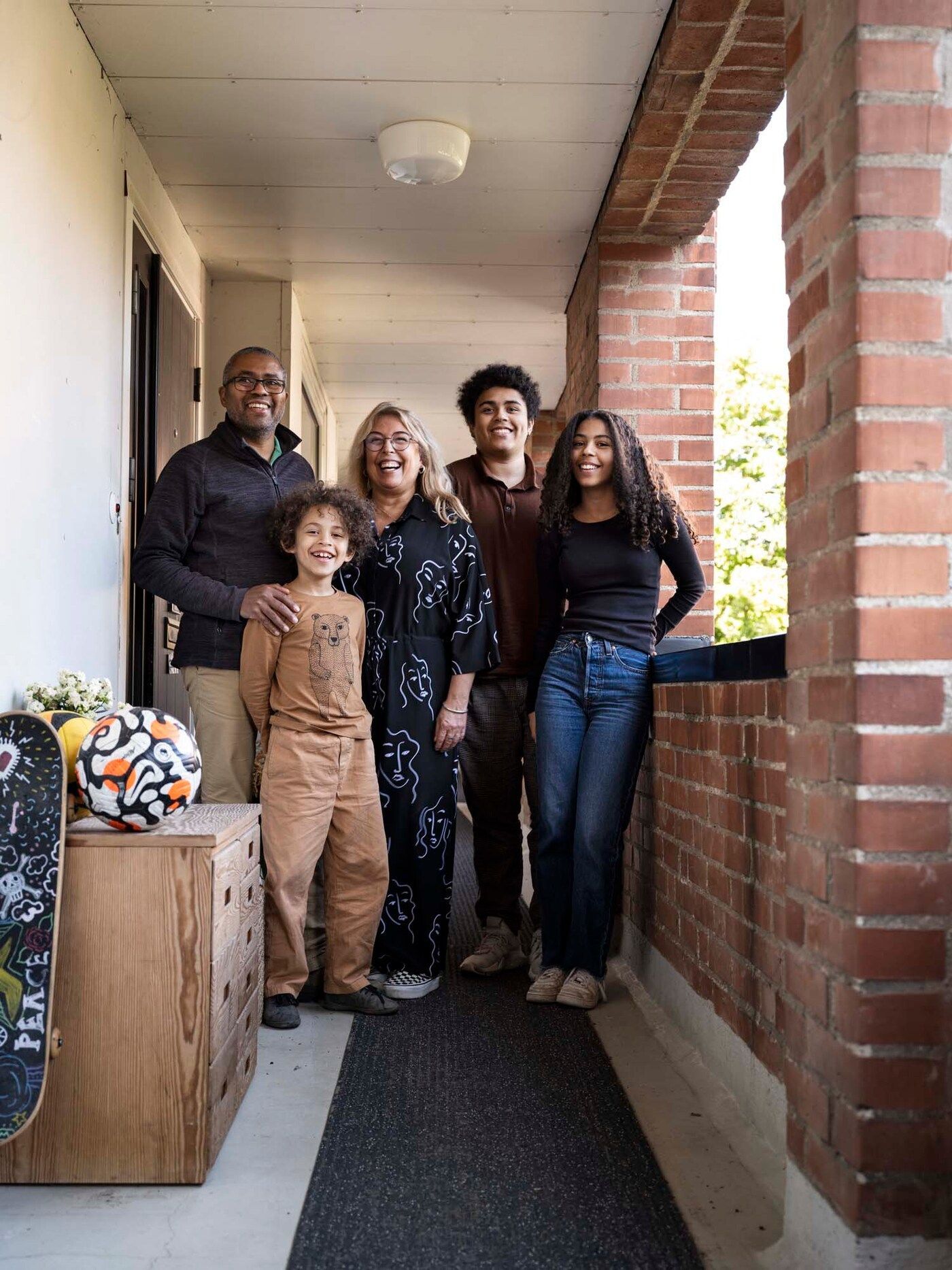 Cecilia, Cédric and family stand on the balcony outside their apartment. 