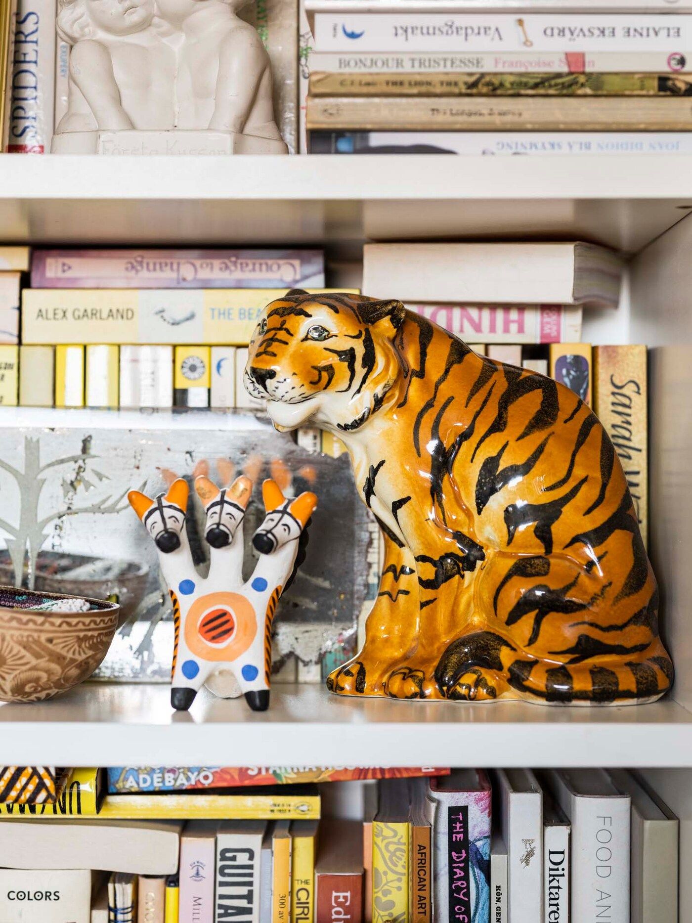 Ornamental animals sit on the bookshelf