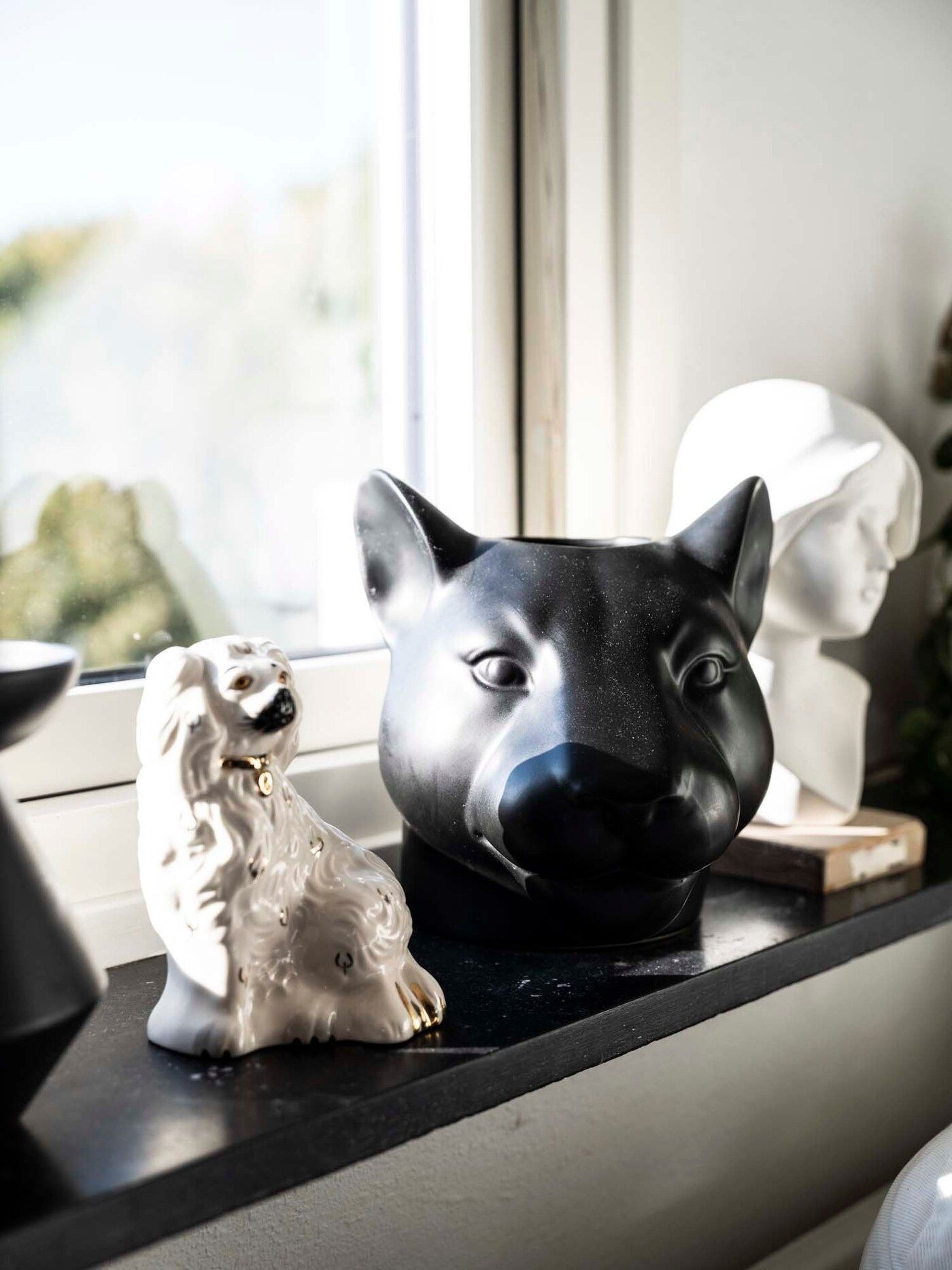 Black and white ornaments sit on a windowsill.