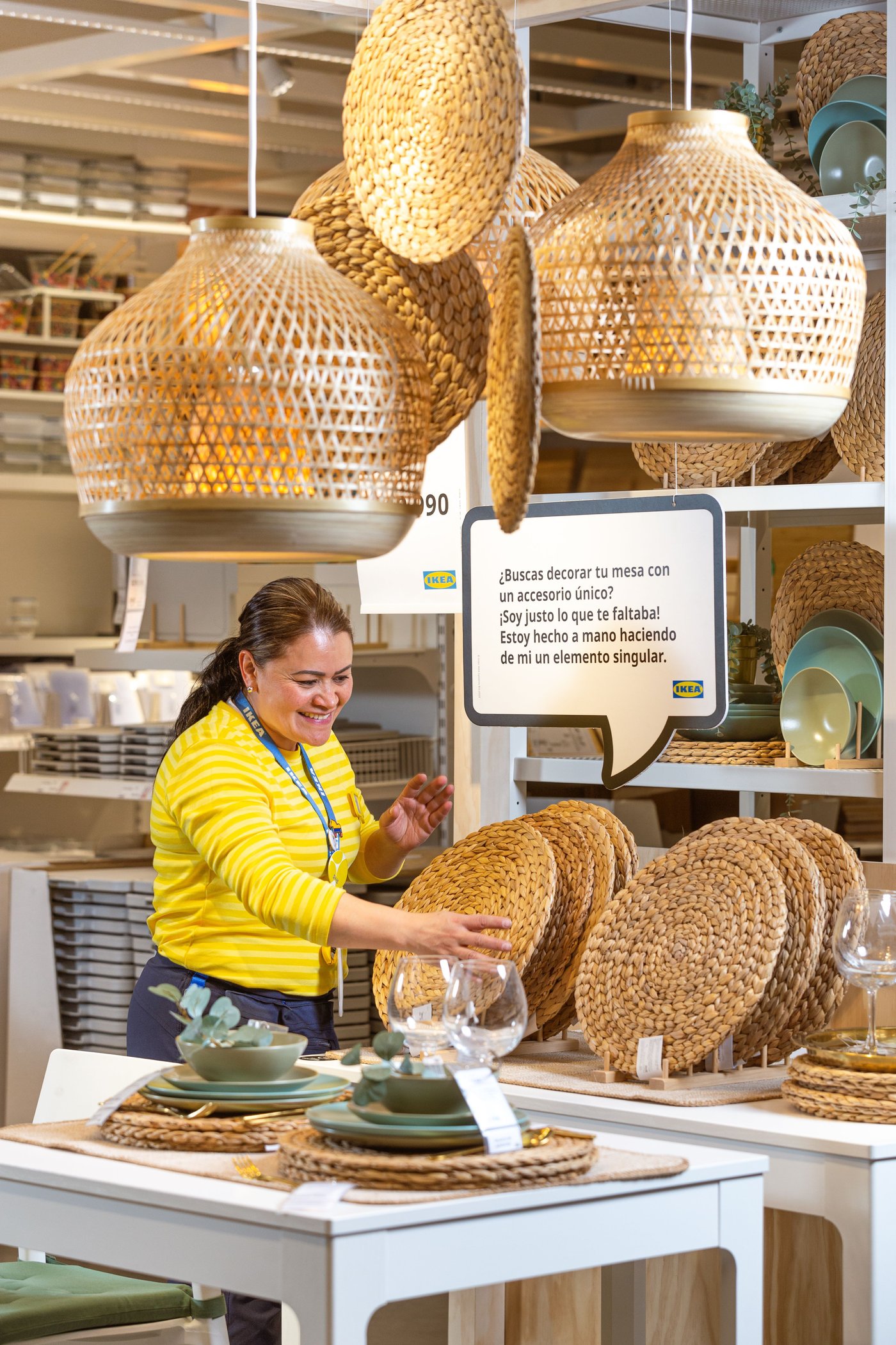 Showroom where rotan lamps are hanging from the ceiling and other rotan accessories laying on the table. A co-worker working to make everything look neat.