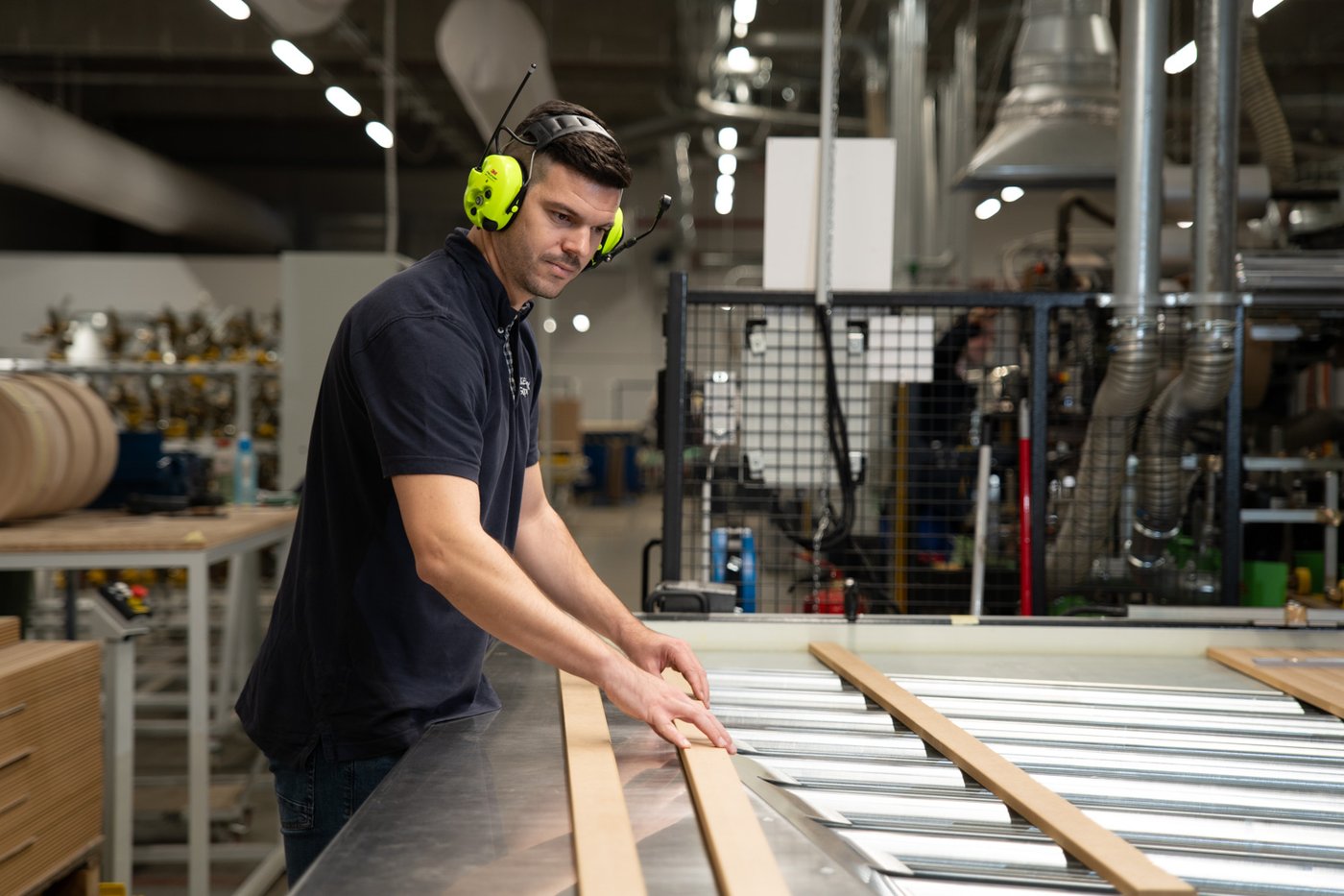 A person wearing headphones in an IKEA Industry factory in Sopron.