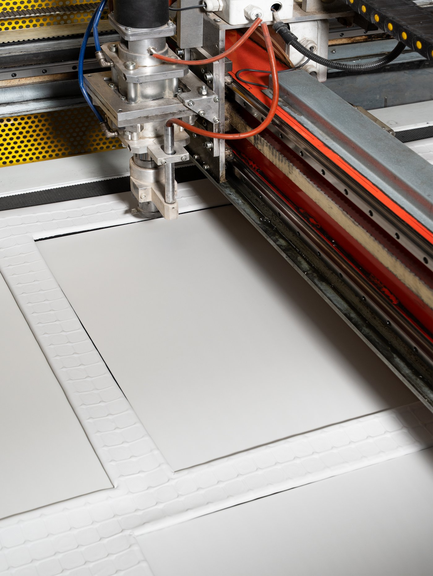 A close-up of a machine cutting out kitchen front panels.