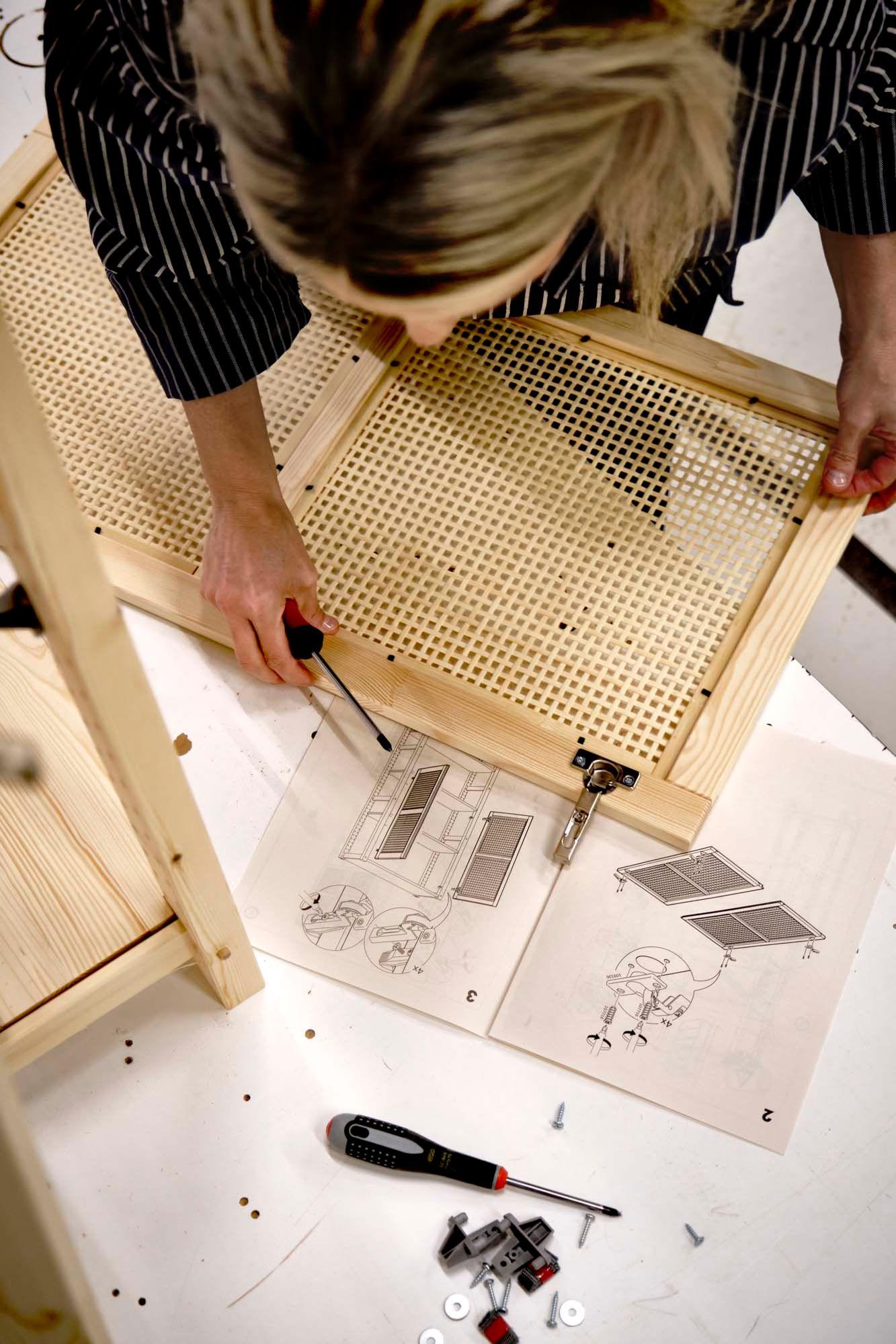 An aerial view of designer Ebba Strandmark looking at construction drawings of a storage unit.