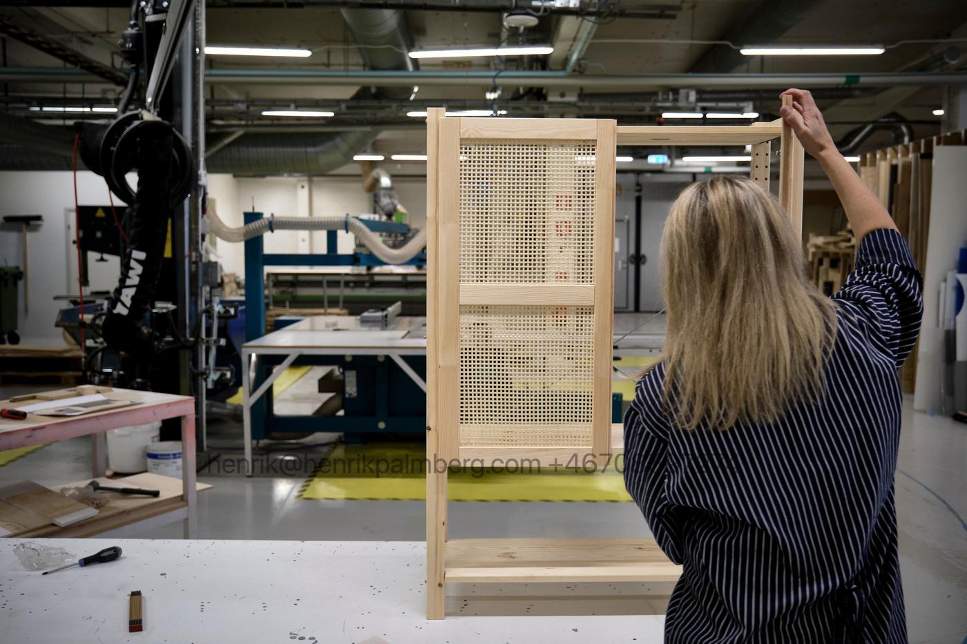 Designer Ebba Strandmark adds bamboo woven doors to a storage unit in a workshop.