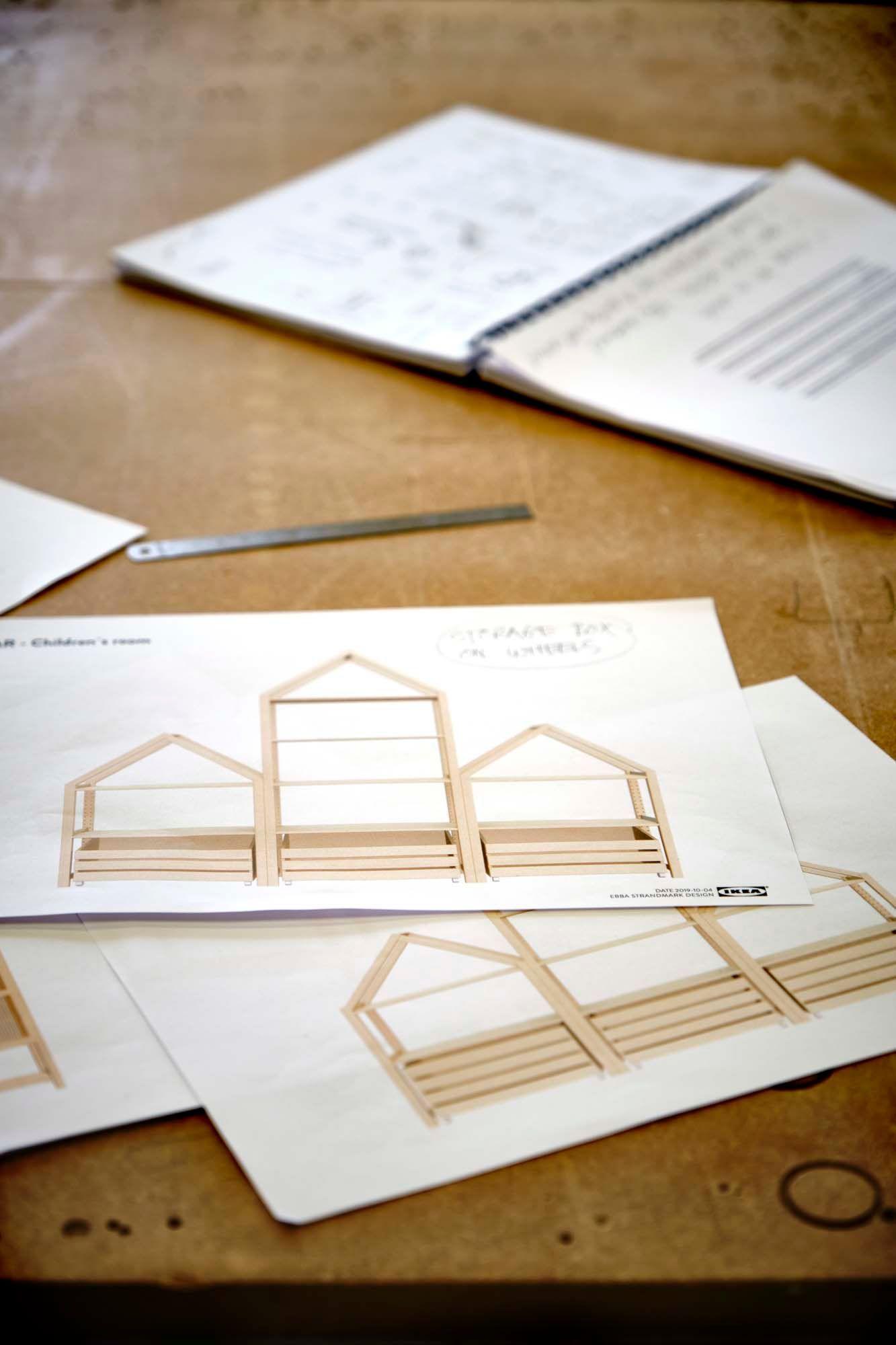 Drawings of a wood storage system design and a notebook on a table.