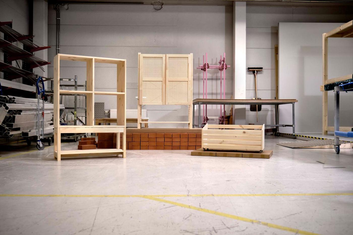 A workshop with three pieces of wood furniture from the IVAR system displayed.
