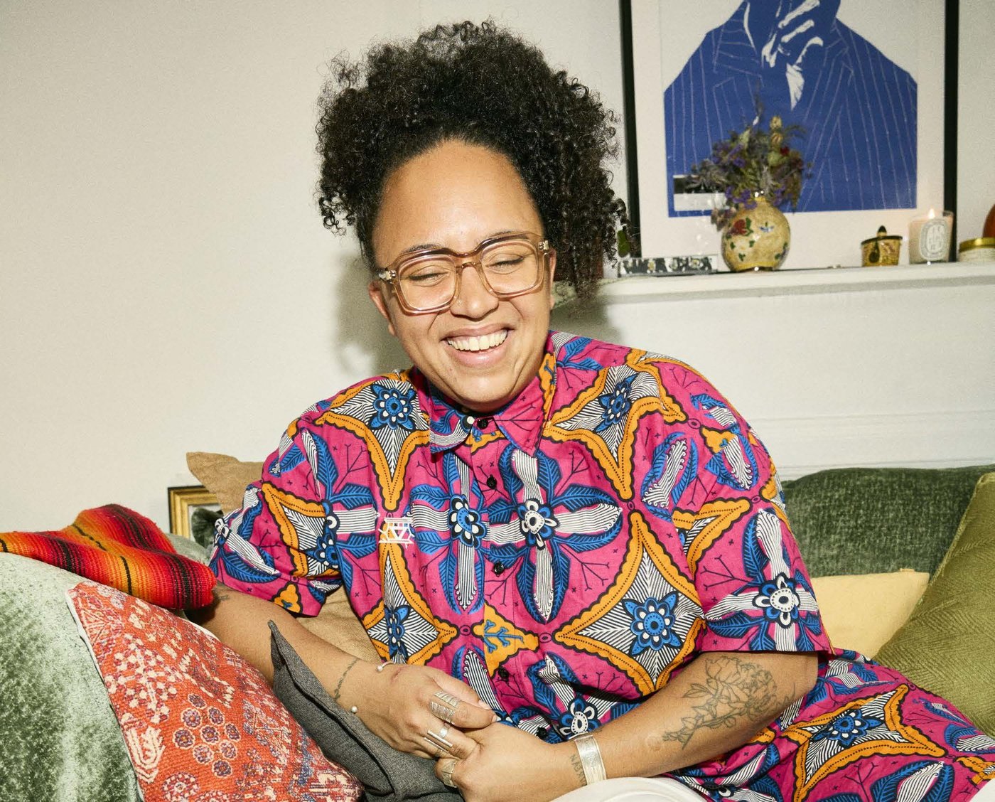 A person sits on a sofa, laughing.