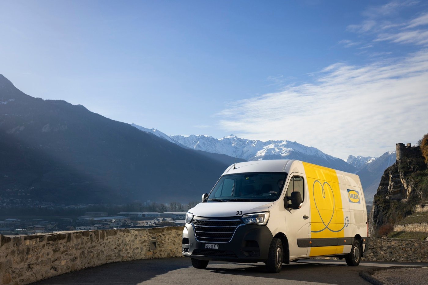 An IKEA EV delivery van driving through a mountainous landscape.