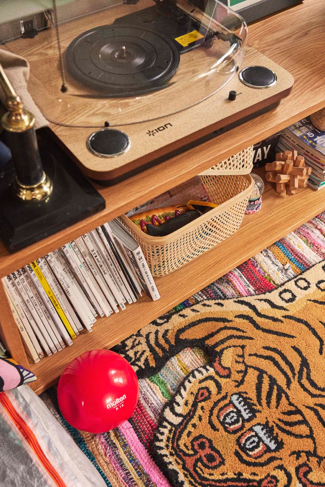 A record player sits atop wooden shelves.