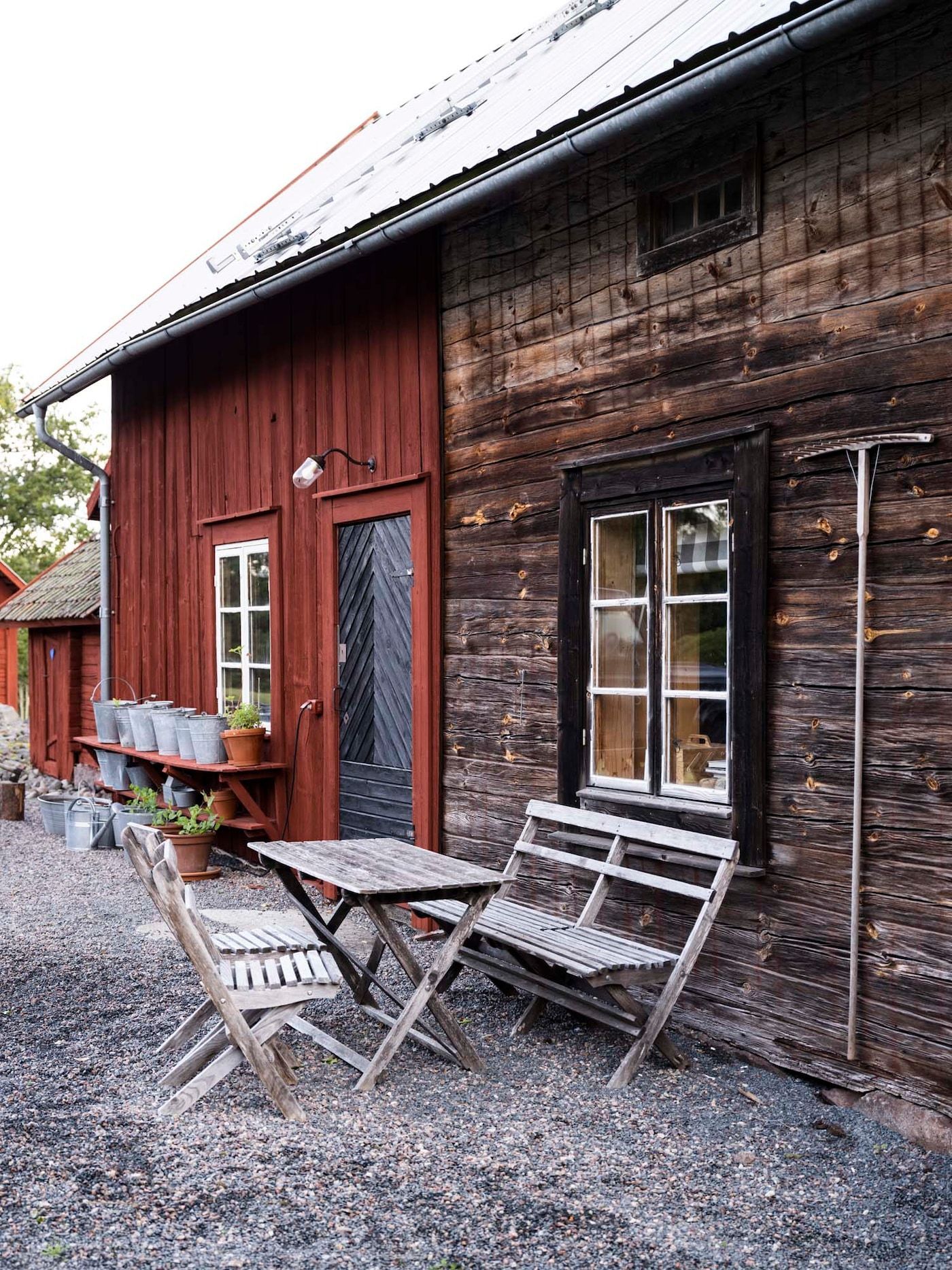 A casual seating with foldable wooden furniture area outside a shed.