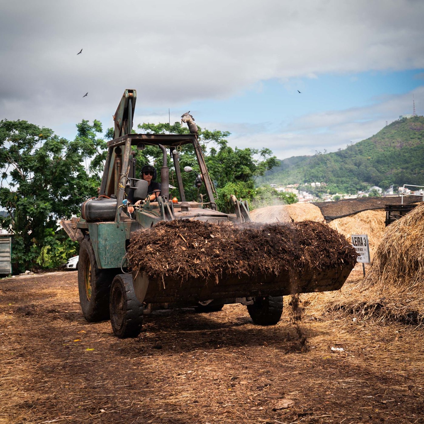 A tractor scoops up waste.