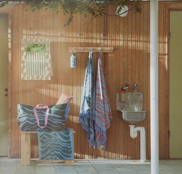 A bathrobe and towels hanging on a wooden wall in a sauna light sauna environment. 
