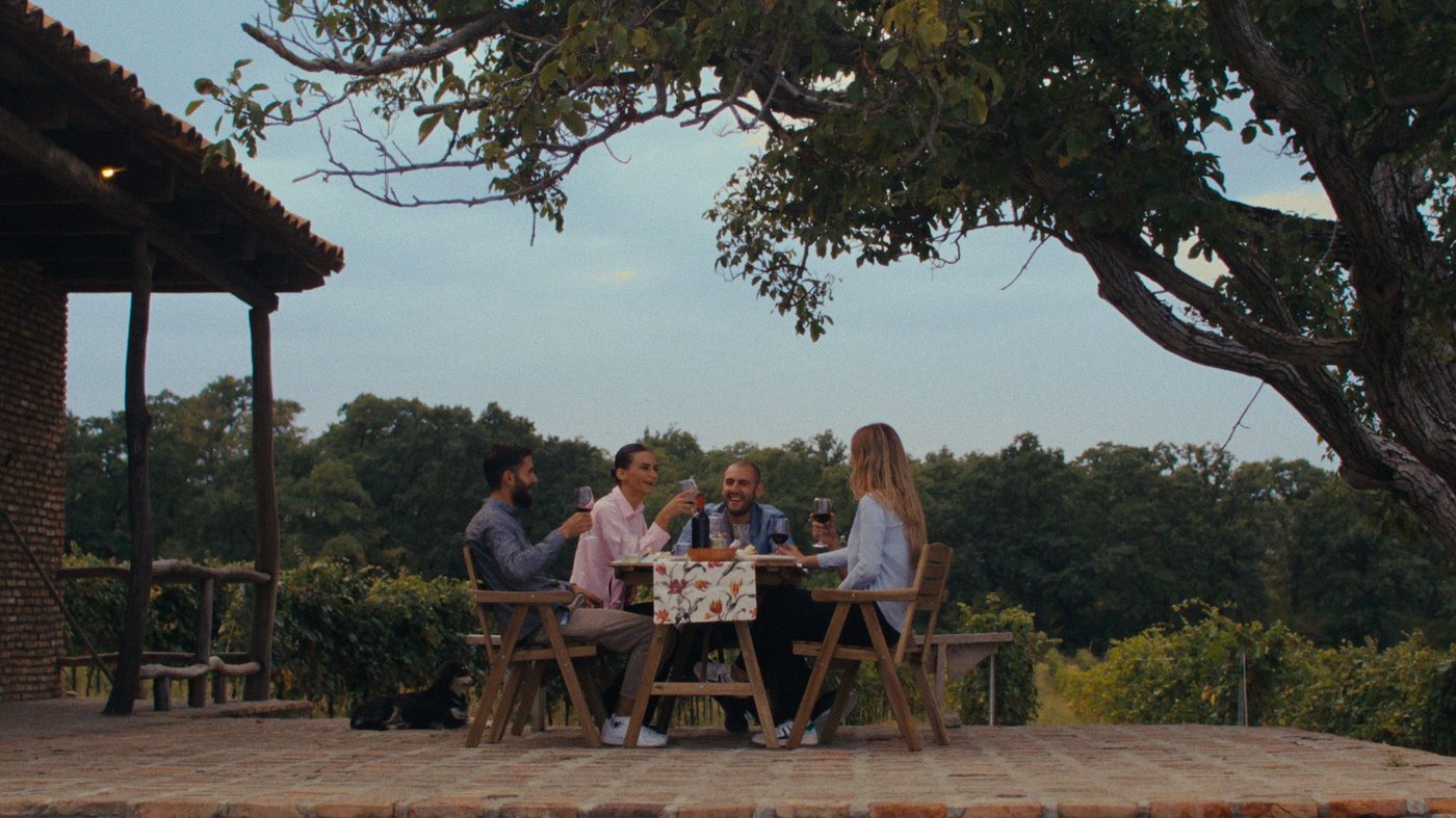 A group of people dining on the terrace of a Georgian vineyard, furnished with IKEA products.
