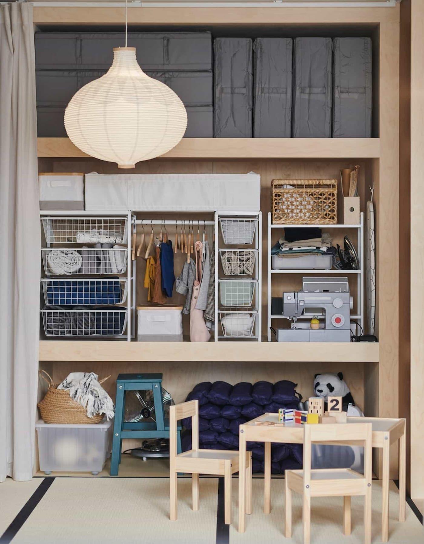Japanese Oshiire open showing storage boxes, wire drawers and table and chairs in front.