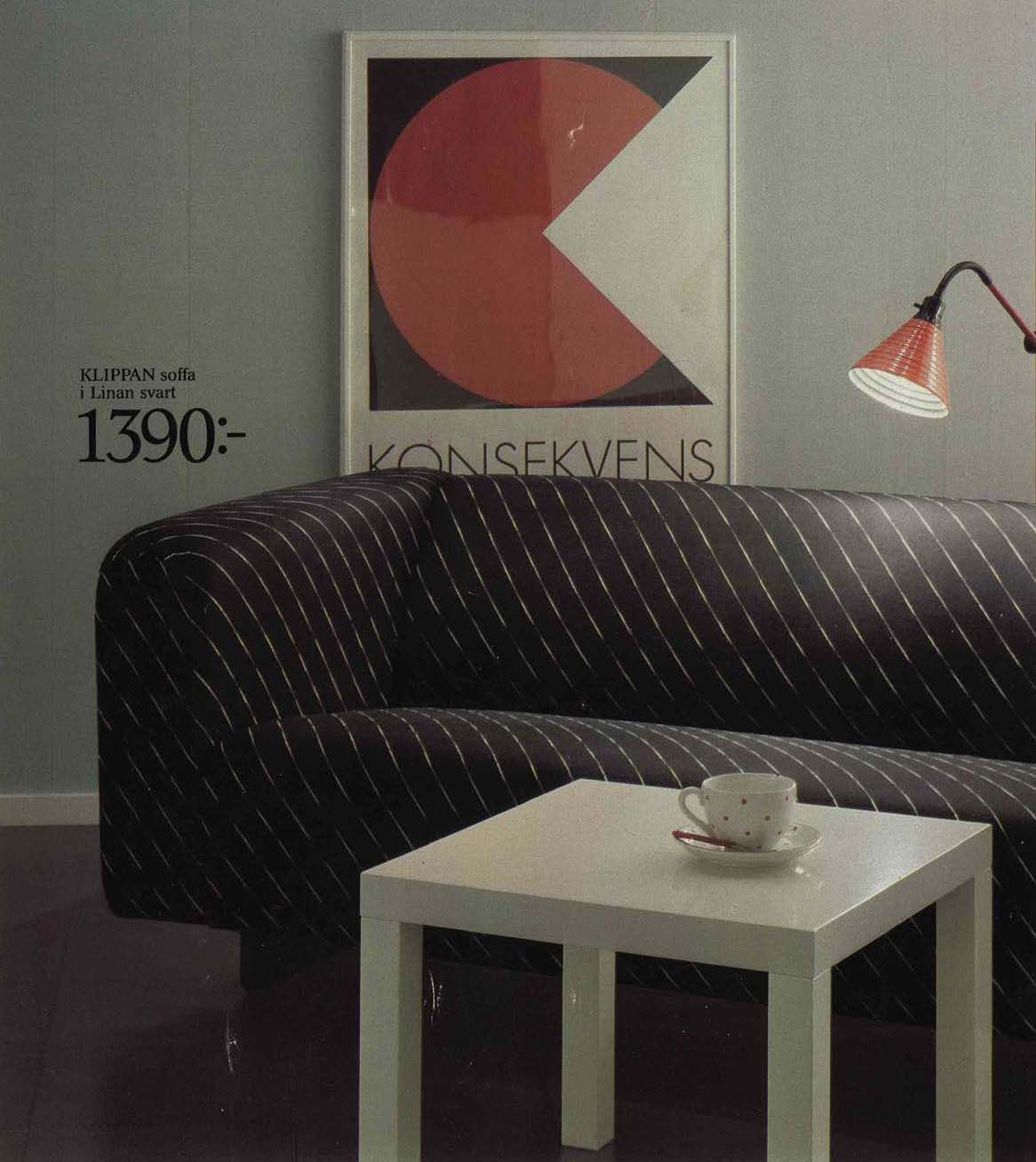 An image from the 1984 IKEA catalogue featuring a black patterned KLIPPAN sofa with a white table, a lamp and a picture hanging behind.