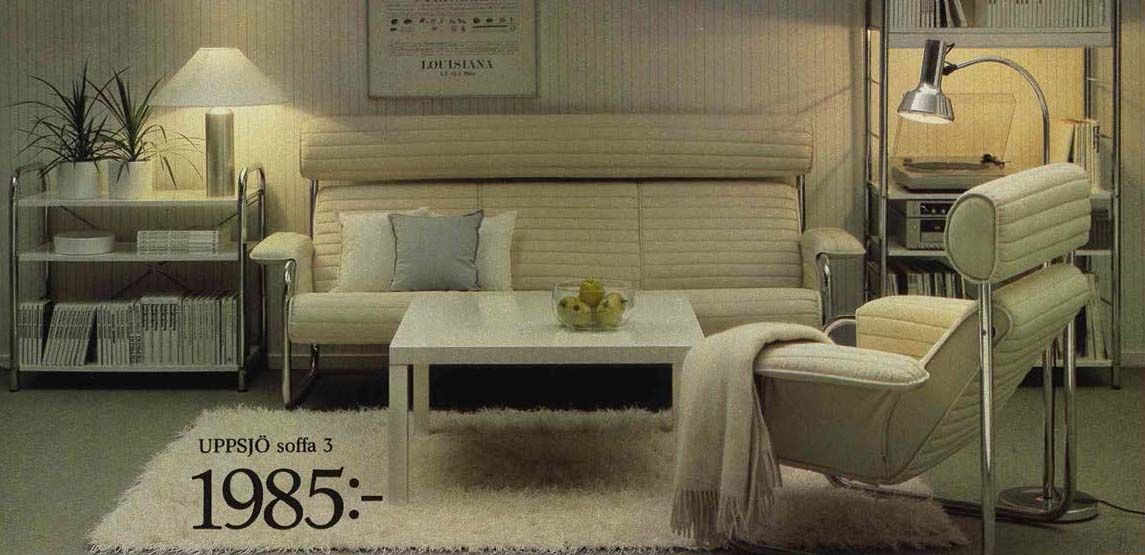 An image from the 1984 IKEA catalogue featuring a white living room with a sofa, armchair and lamps.