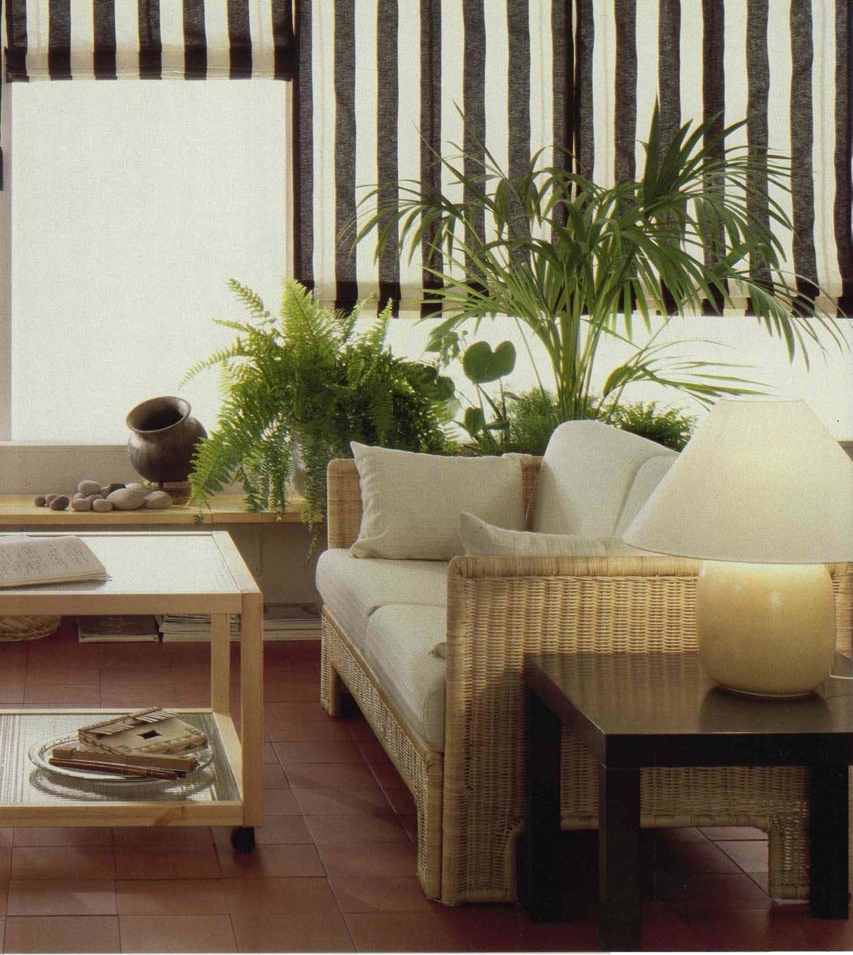An image from the 1984 IKEA Catalogue showing a living room with striped blinds, plants and a white sofa.