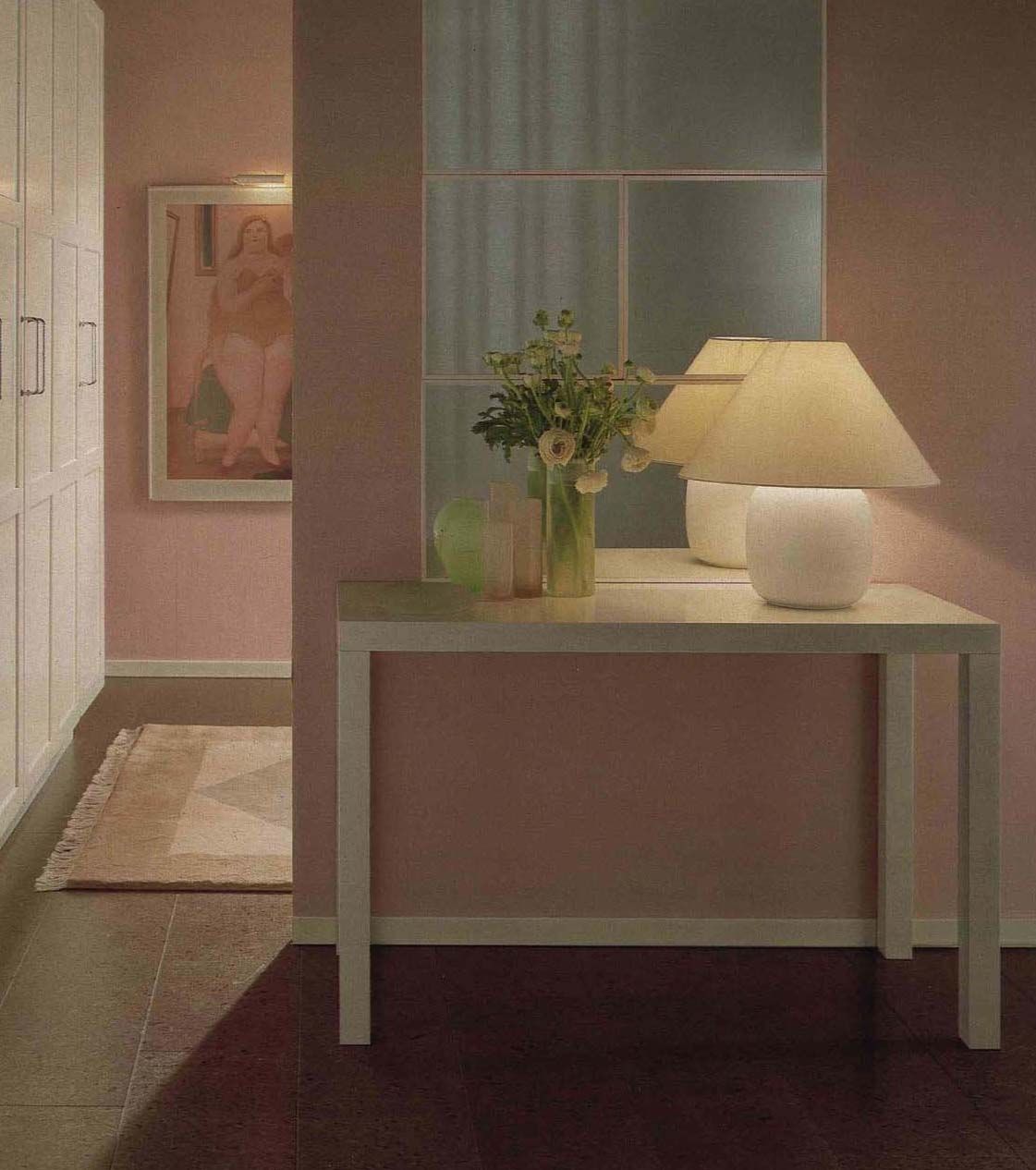 An image from the 1984 IKEA catalogue featuring a pink hallway with white furniture and a table lamp.