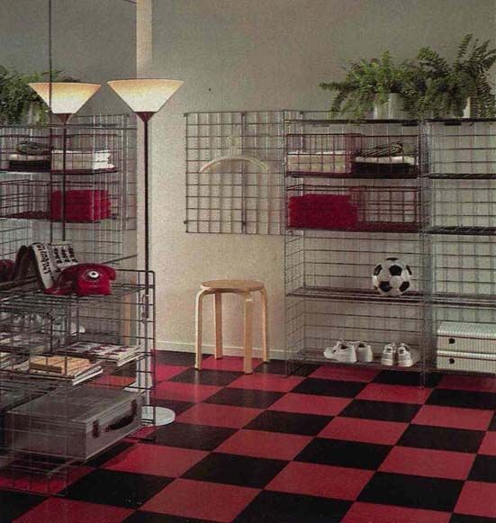 An image from the 1984 IKEA Catalogue, featuring a hallway with a  red and black floor and metal mesh shelving.