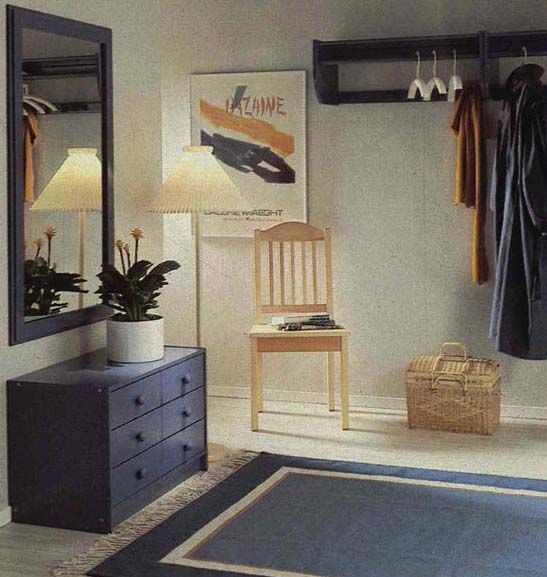 A photo from the 1984 IKEA Catalogue, featuring a hallway with blue and white furniture and a blue rug. 