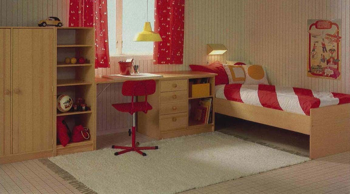 A red and white bedroom with a striped duvet cover on the bed and a wooden desk, shown in the 1984 IKEA Catalogue.