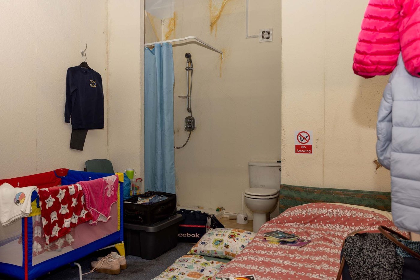 The tiny real-life roomset in Birmingham filled with a bed, baby's cot, clothing and bags.