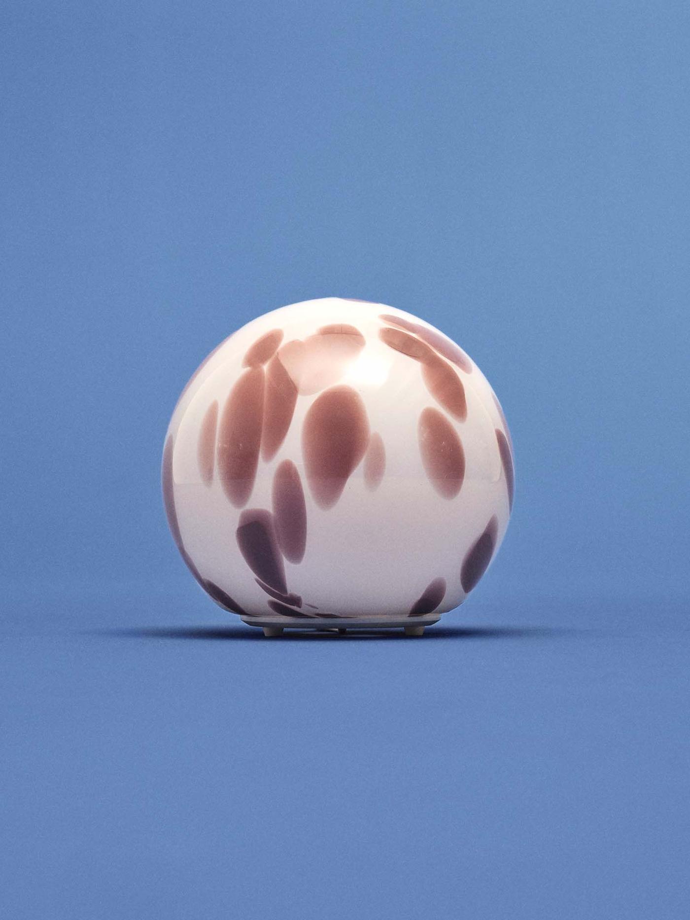 A round, patterned FADO lamp against a blue backdrop.