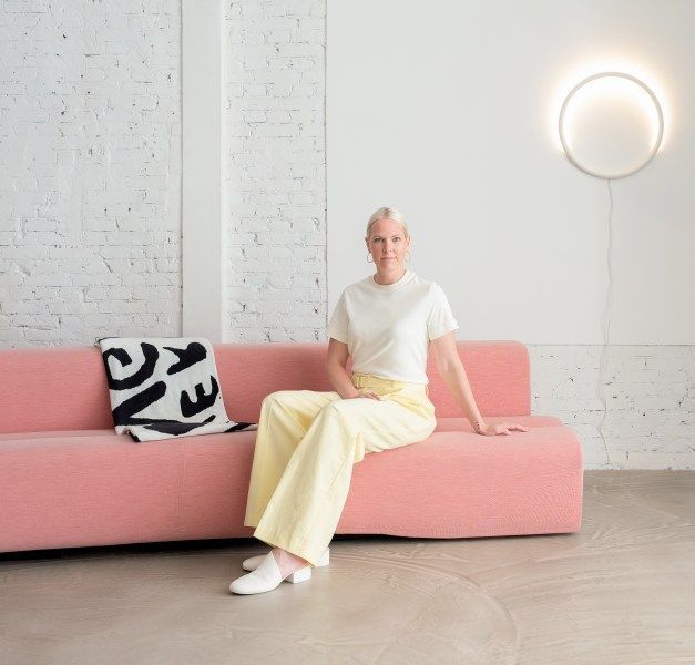 Designer Sabine Marcelis sits on a pink sofa.