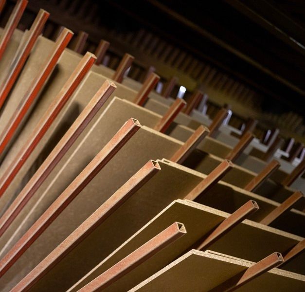 Particle boards lying on a rack in an industrial environment.