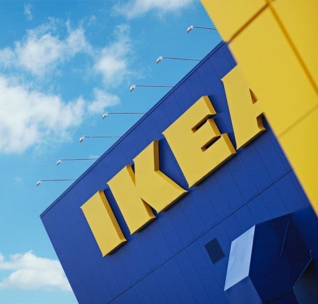 The facade of an IKEA store, with a sign with the IKEA logo.