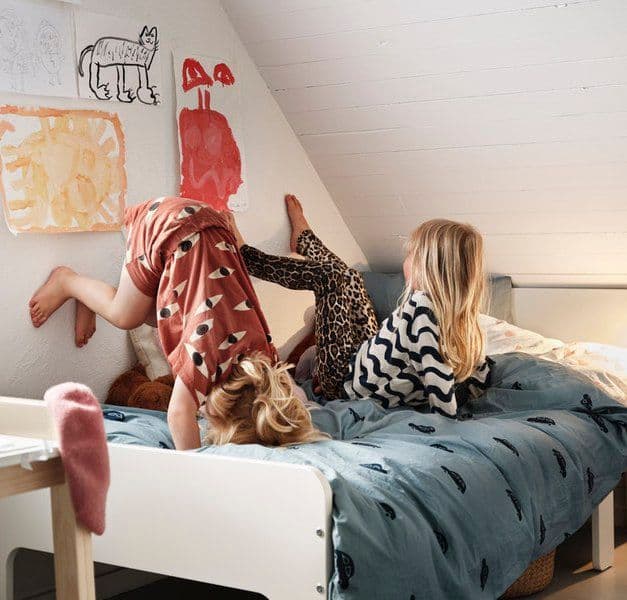 Two children playing i kids bed.