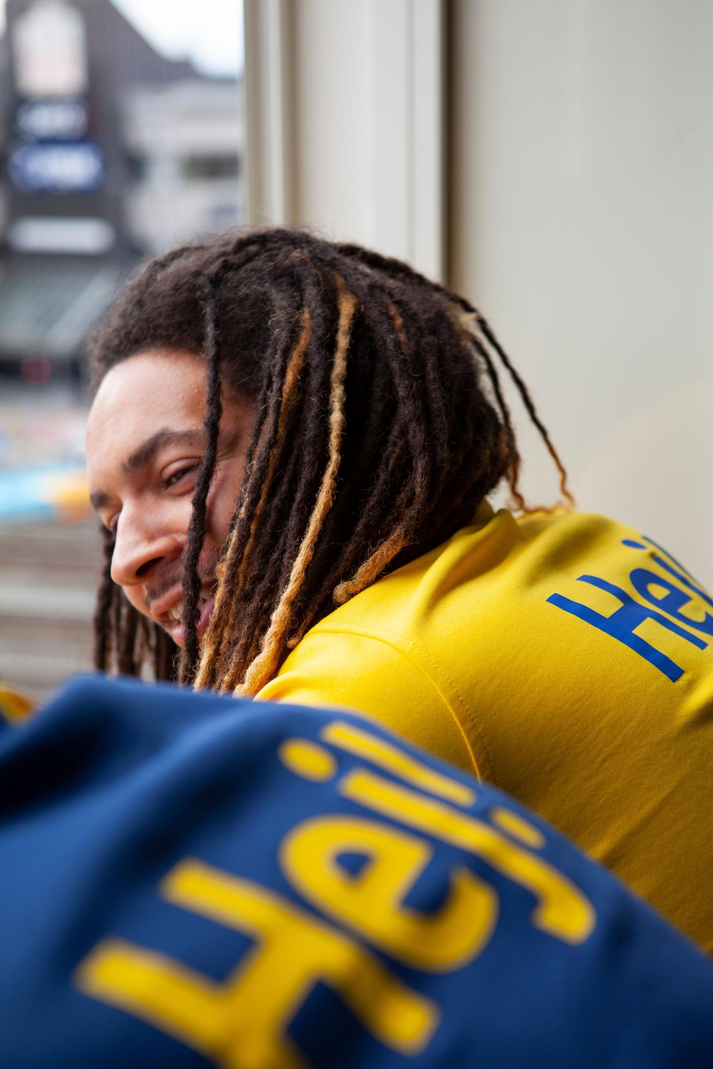 An IKEA co-worker wearing a yellow t-shirt that says "Hej!" on the back.