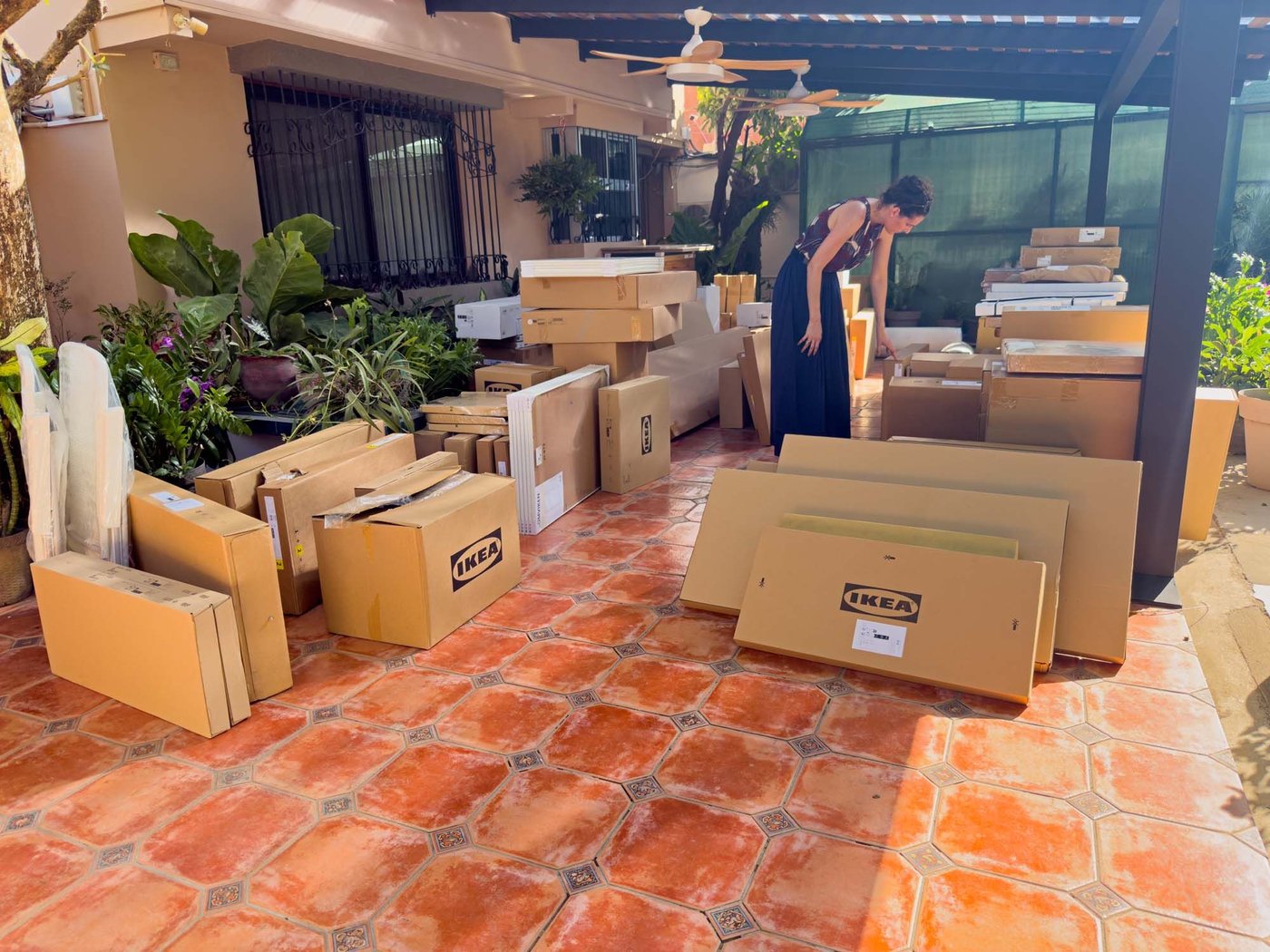 Amelie looks at some of the IKEA delivery boxes that are placed around her outdoor terrace area.