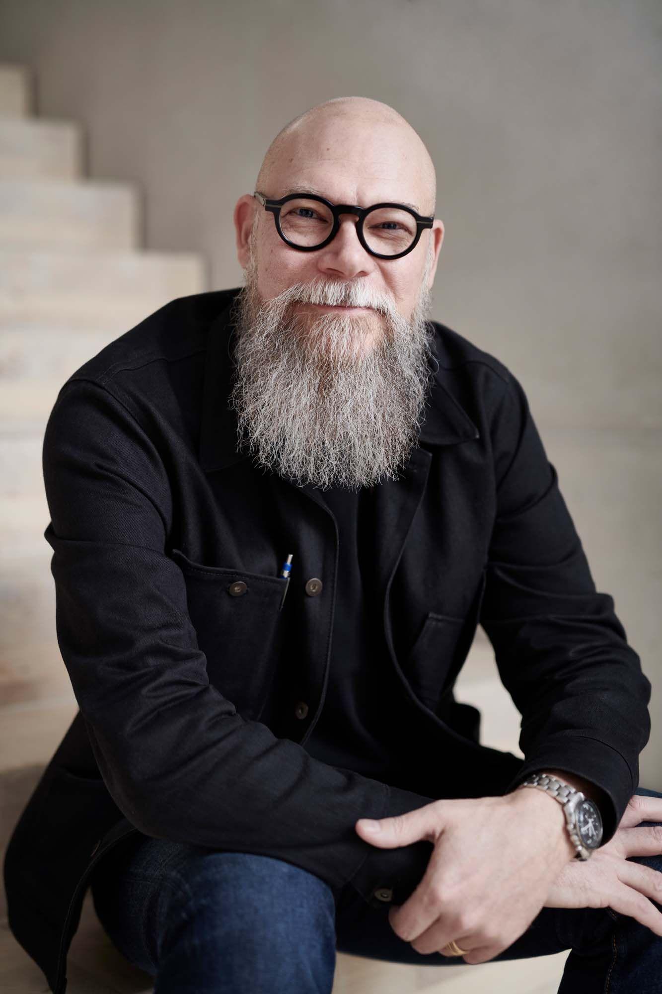 Johan Ejdemo sits on a step and smiles at the camera.