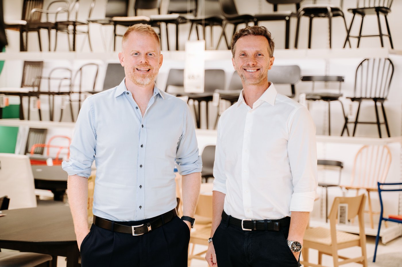 Jon Abrahamsson Ring and Kuba Jankowski stand in front of a wall of many chairs, displayed in rows. They smile at the camera.
